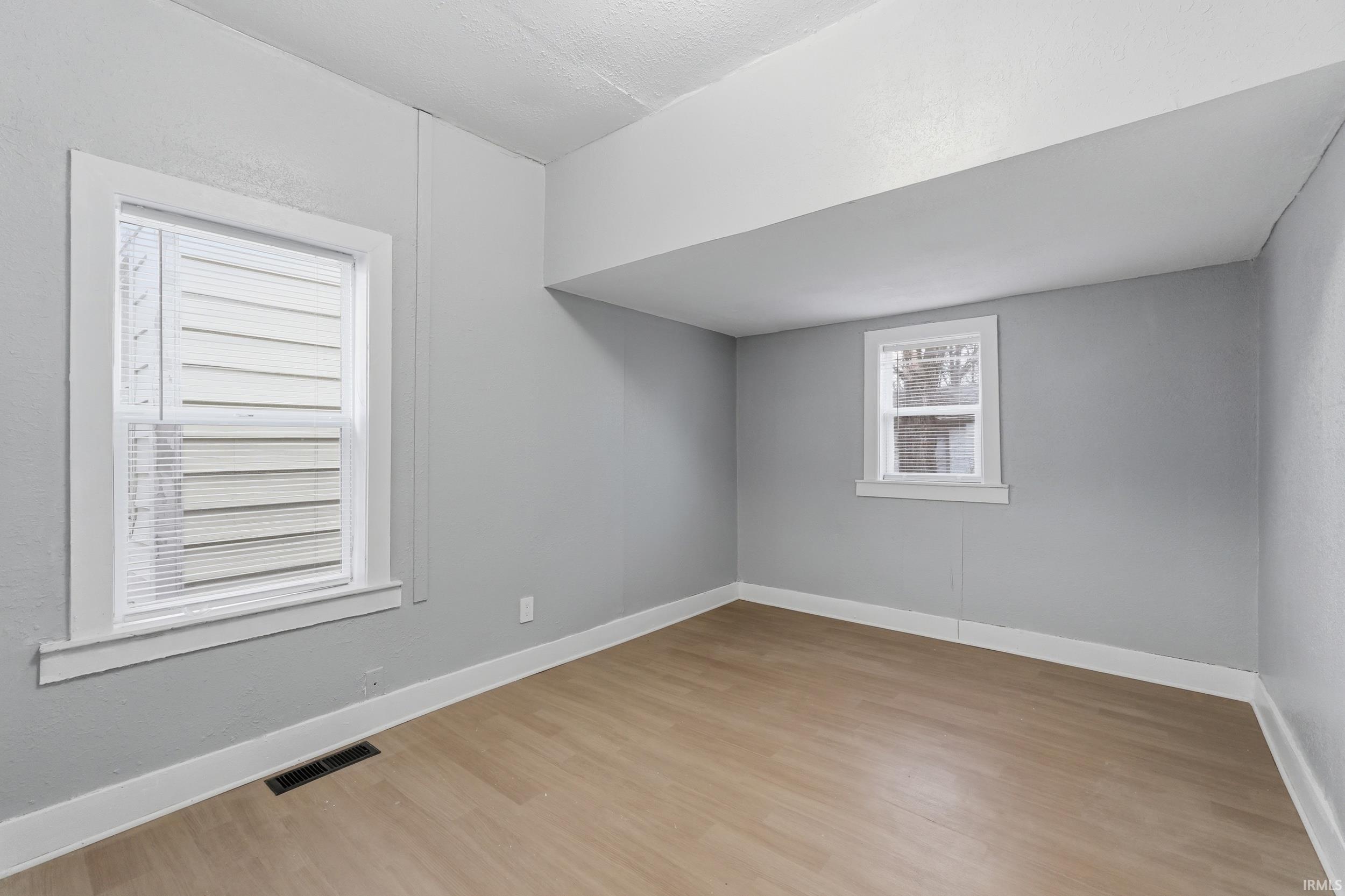 Empty room with light wood-style floors and baseboards