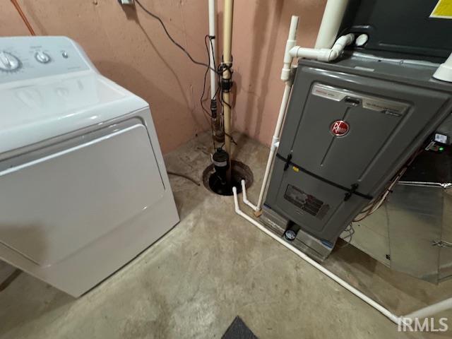 Laundry area featuring washer / dryer, concrete floors, and heating unit