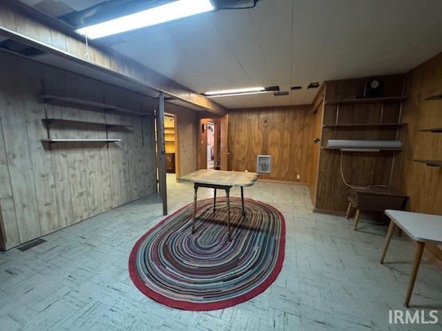 Finished basement featuring wood walls and light flooring