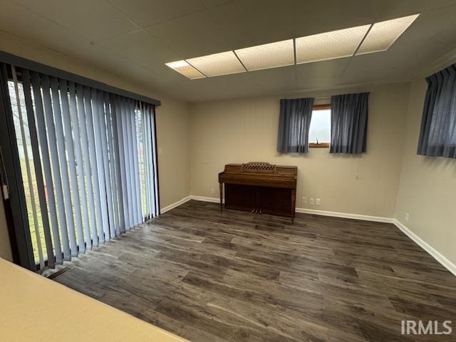 Empty room featuring dark wood finished floors and baseboards