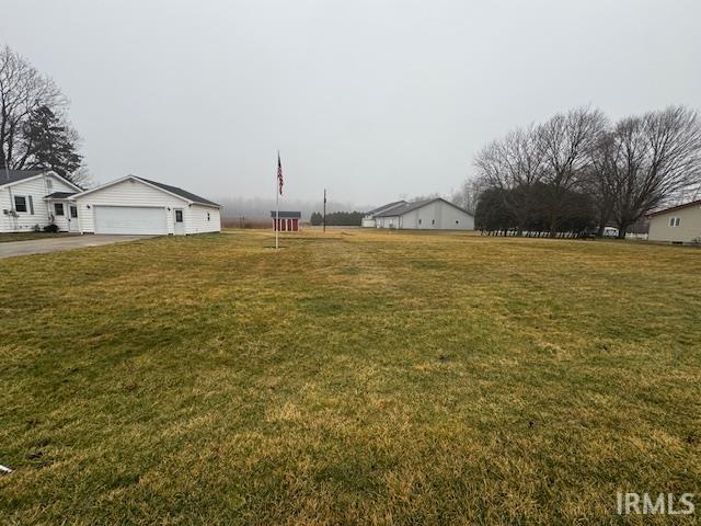 View of grassy yard with a garage