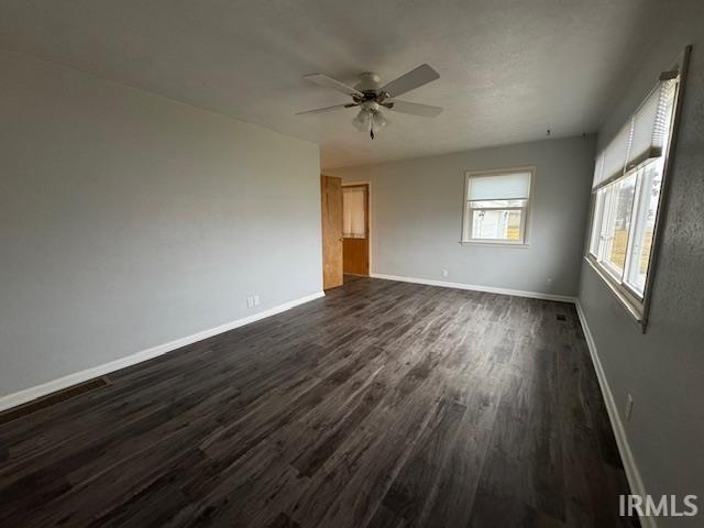 Unfurnished bedroom with dark wood-style floors and a ceiling fan