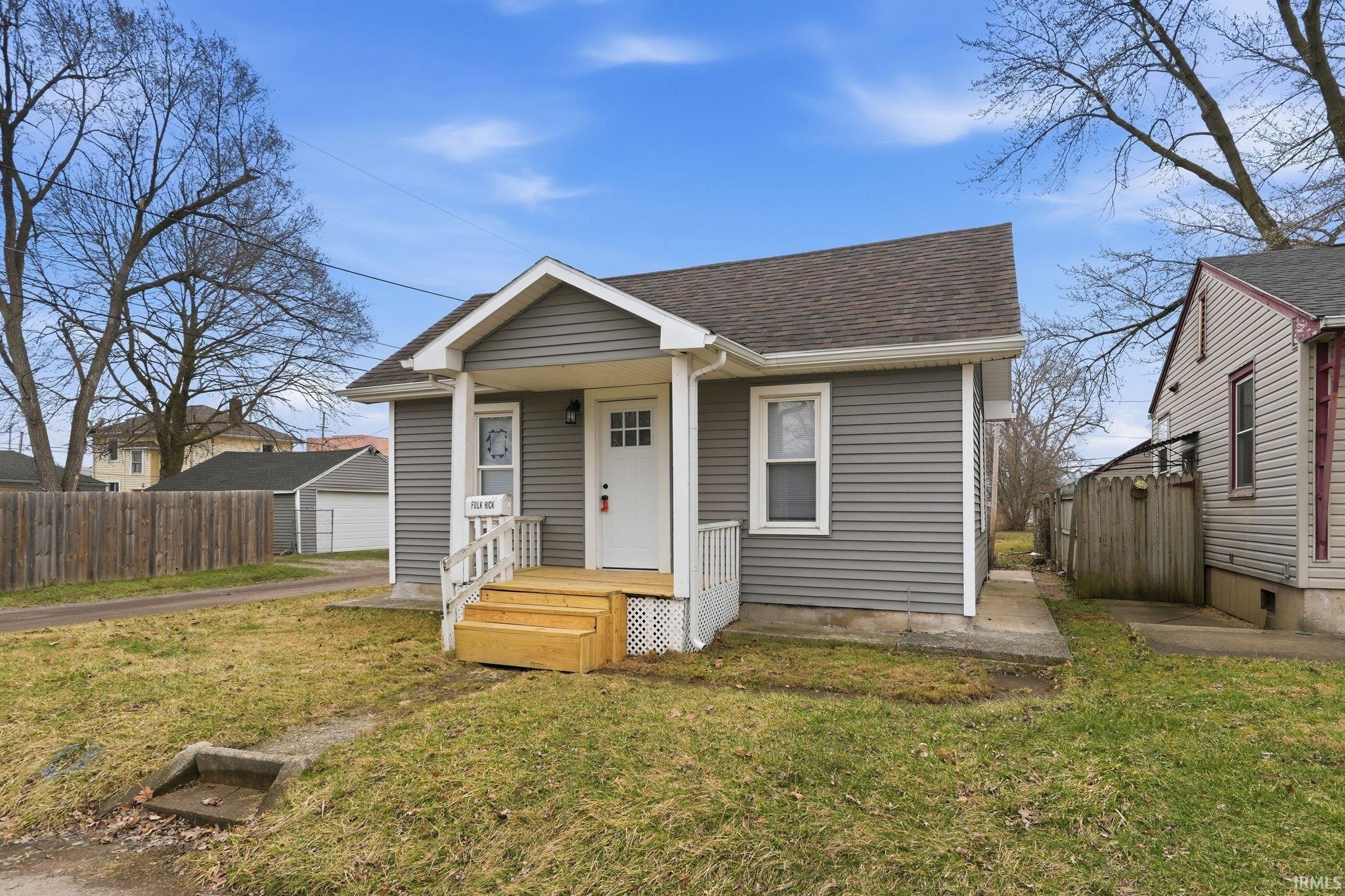 Bungalow-style home featuring roof with shingles and a porch