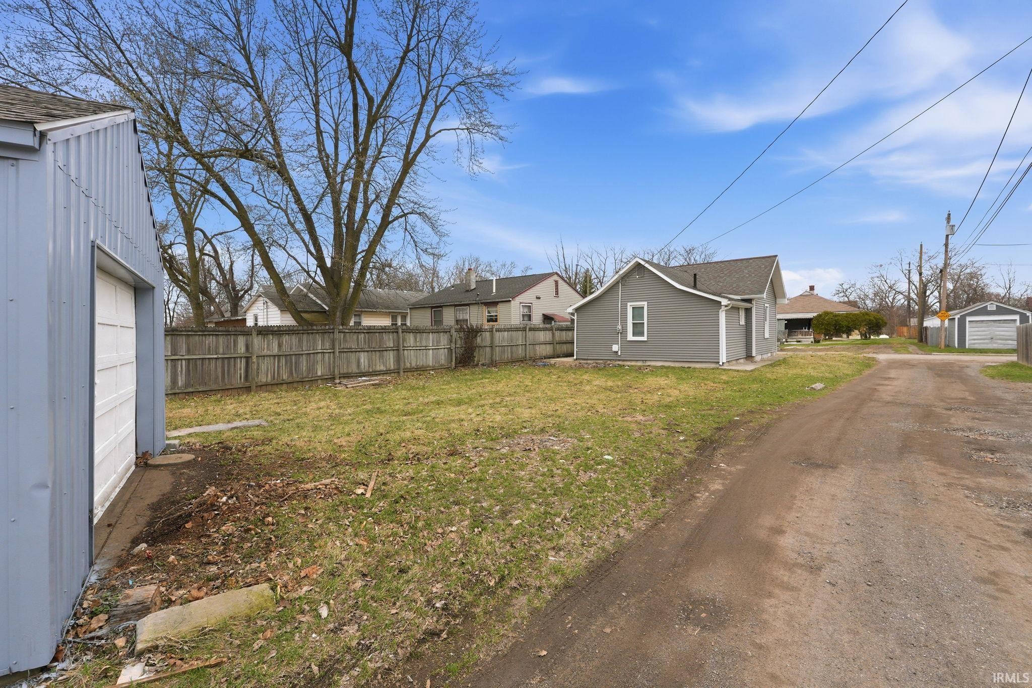 View of yard with an outbuilding, a residential view, and a garage