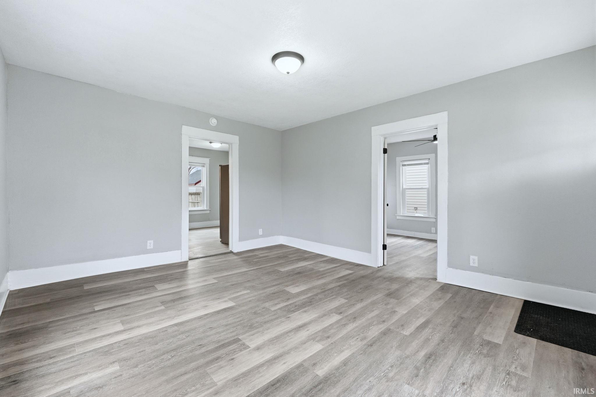 Empty room with light wood-style floors and ceiling fan