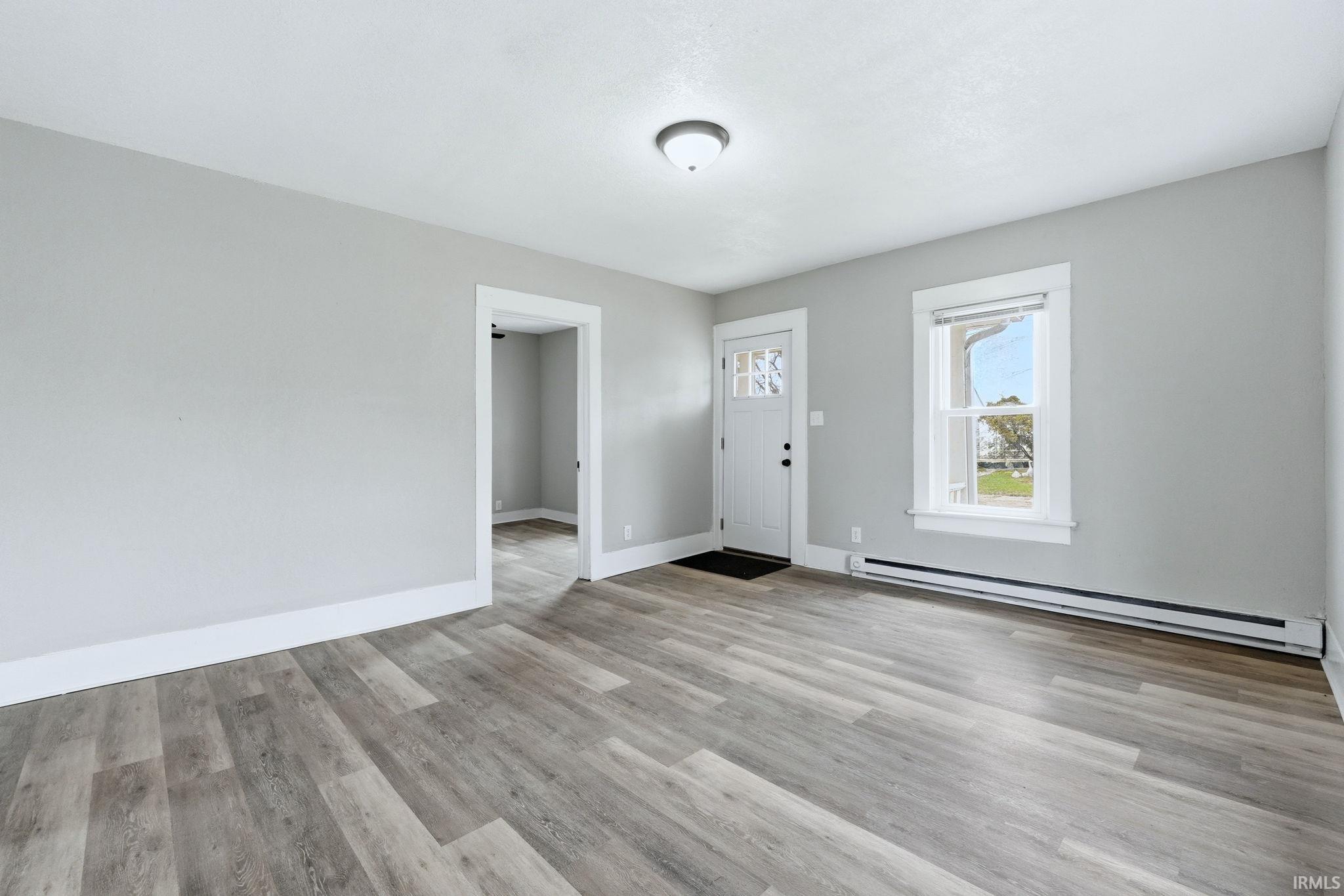 Foyer featuring a baseboard radiator and light wood finished floors