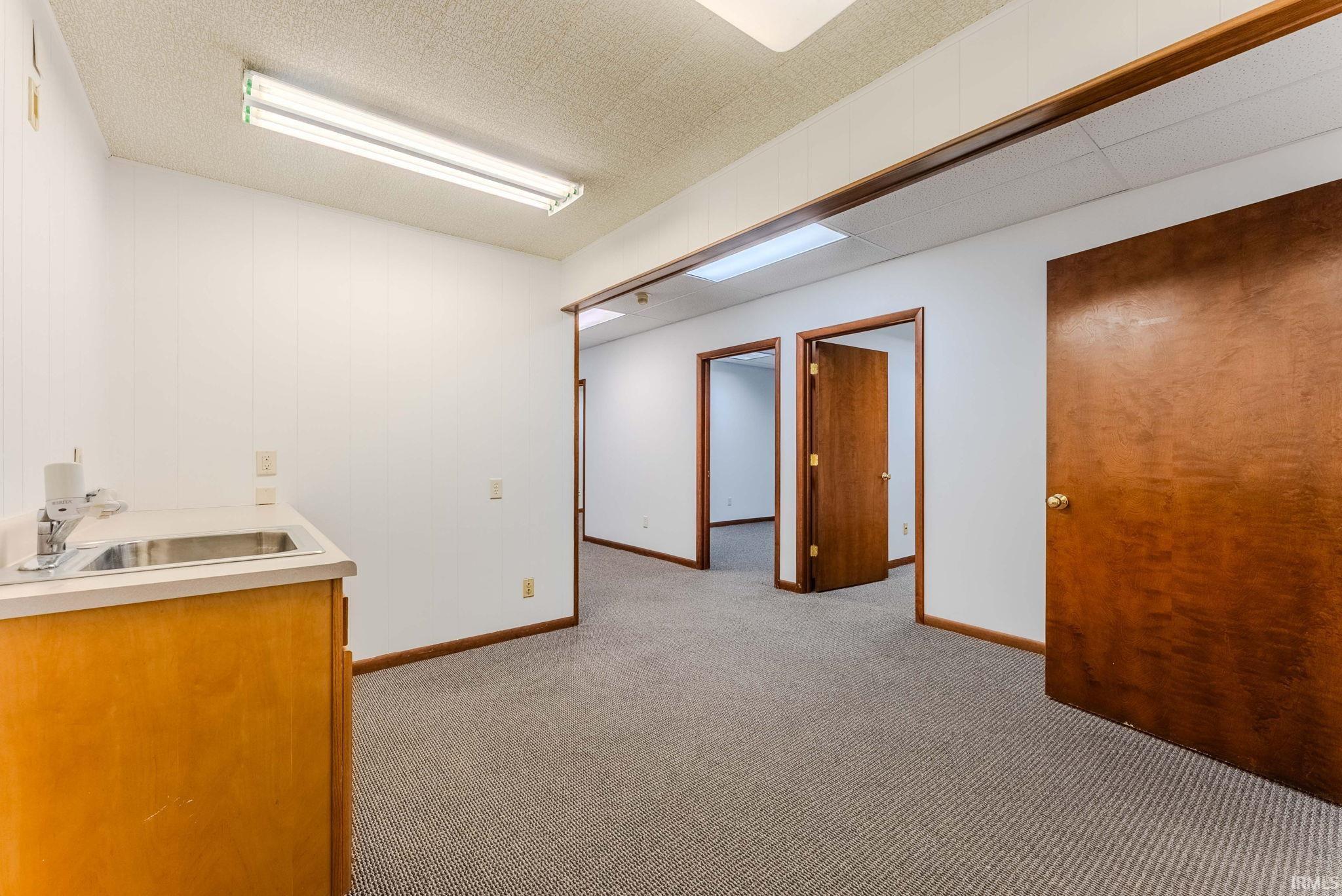 Interior space featuring light colored carpet and a sink