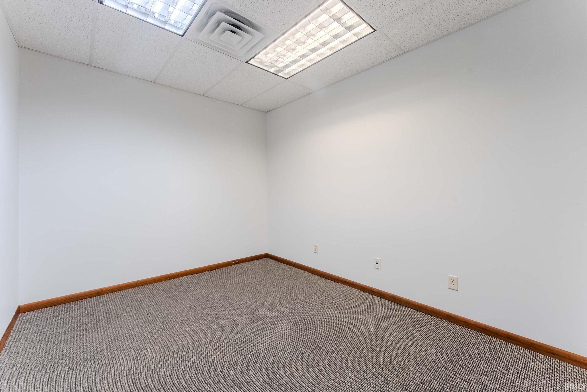 Carpeted spare room featuring a paneled ceiling