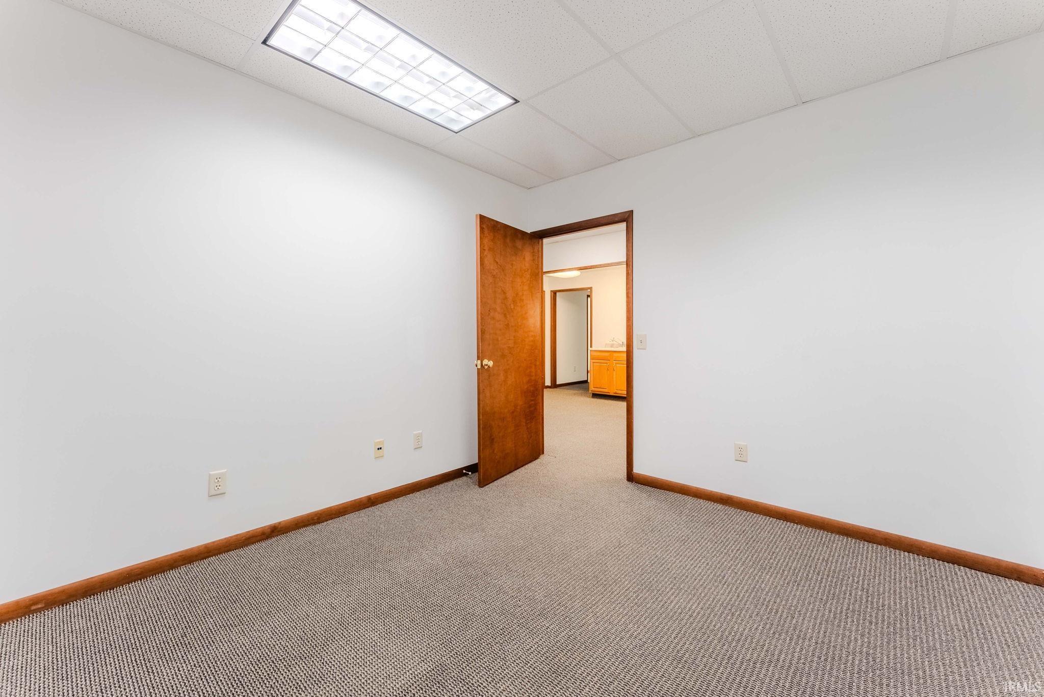 Unfurnished room with a drop ceiling and light carpet