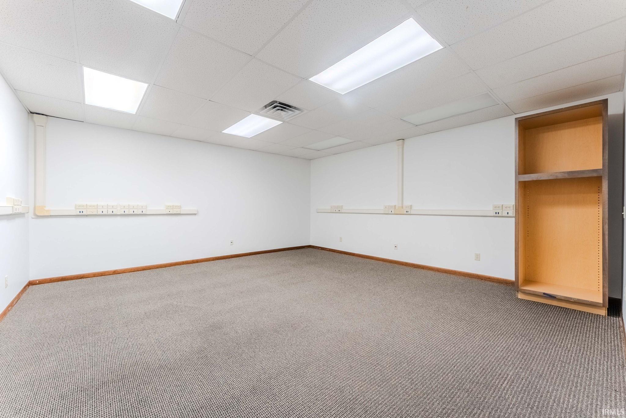 Basement featuring a paneled ceiling and light carpet
