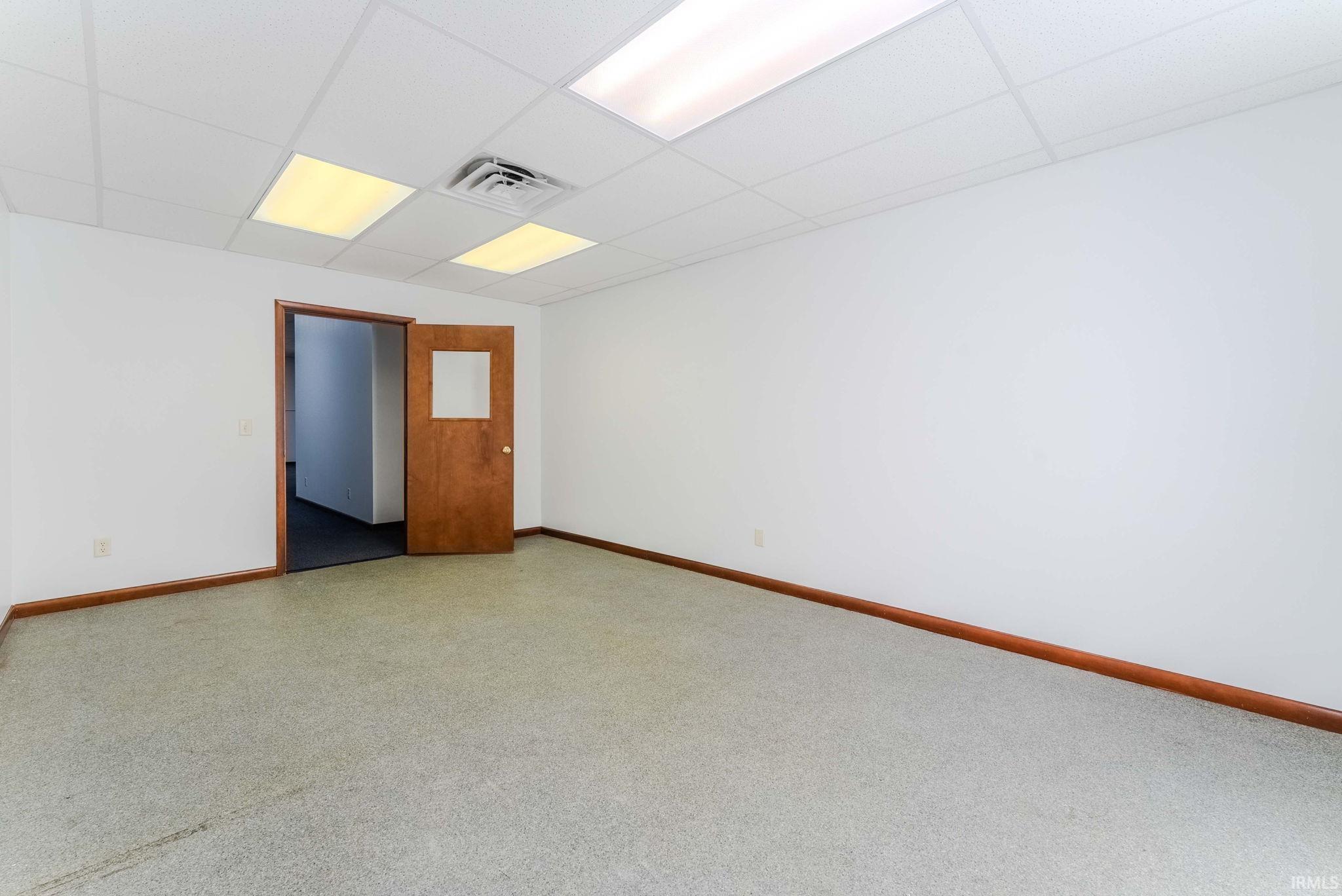 Spare room with baseboards and a paneled ceiling