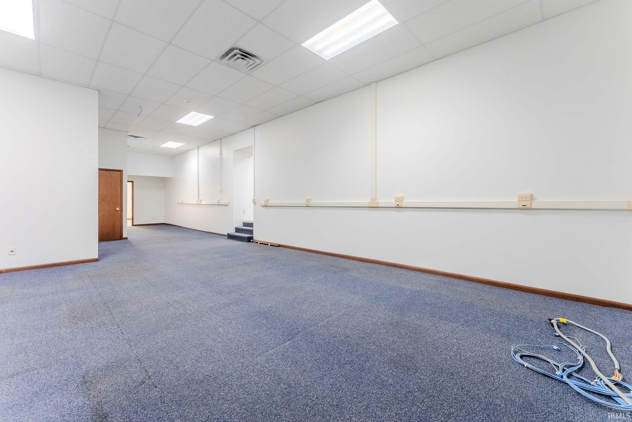 Spare room featuring a paneled ceiling and carpet floors