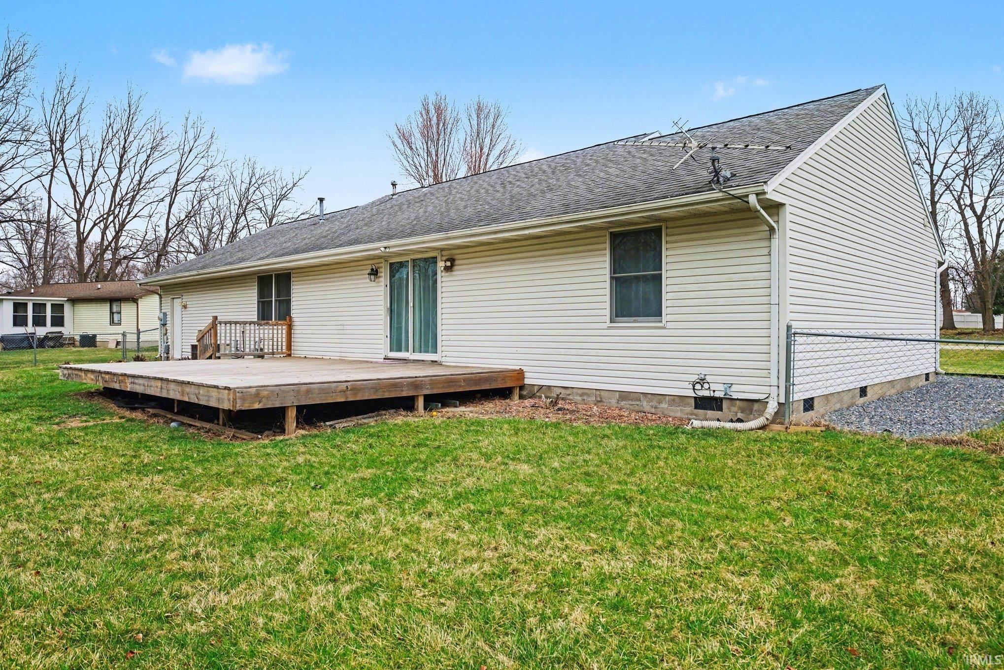 Rear view of property with large open deck off from the living room