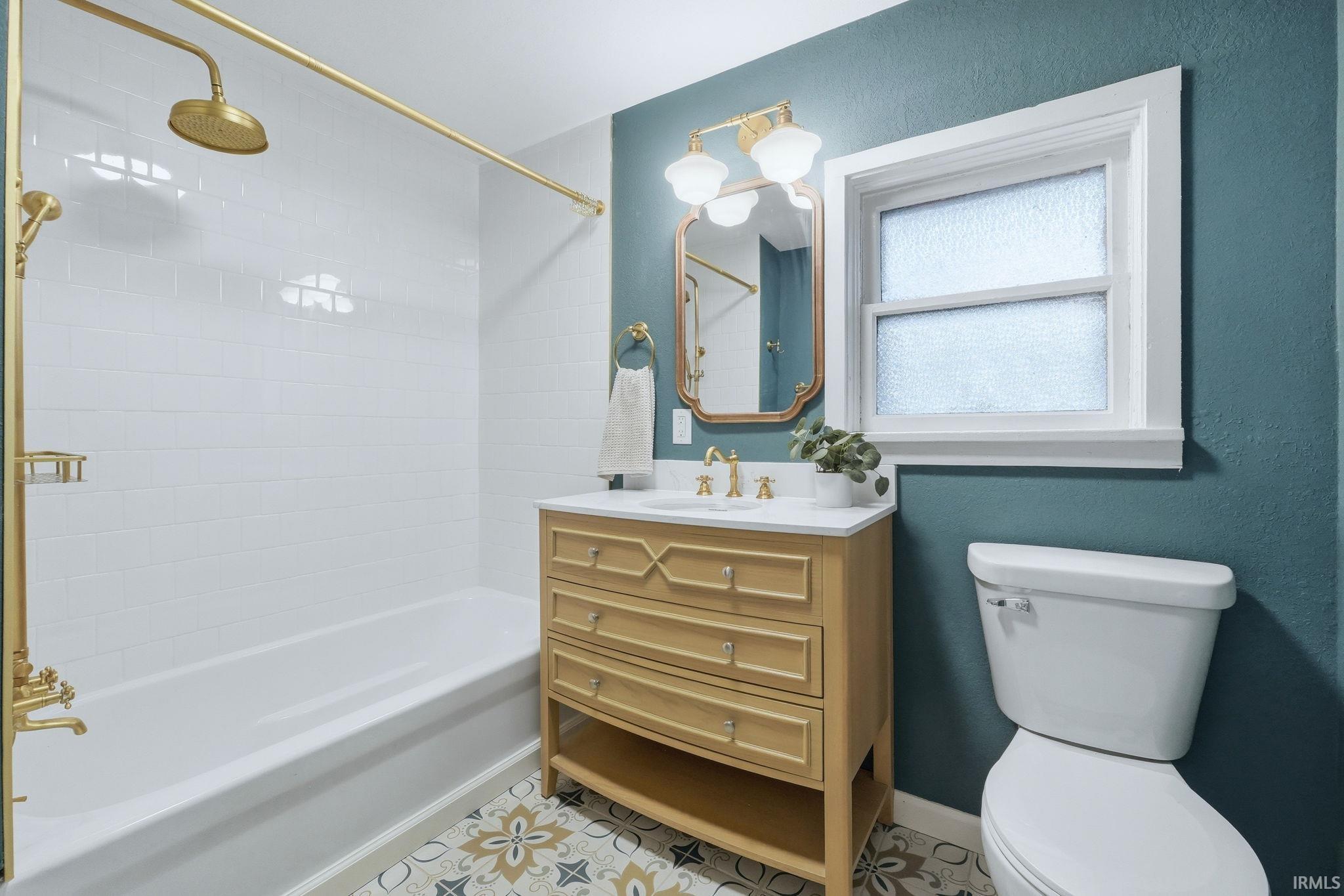 Bathroom featuring vanity and a combined bath / shower with rainfall shower