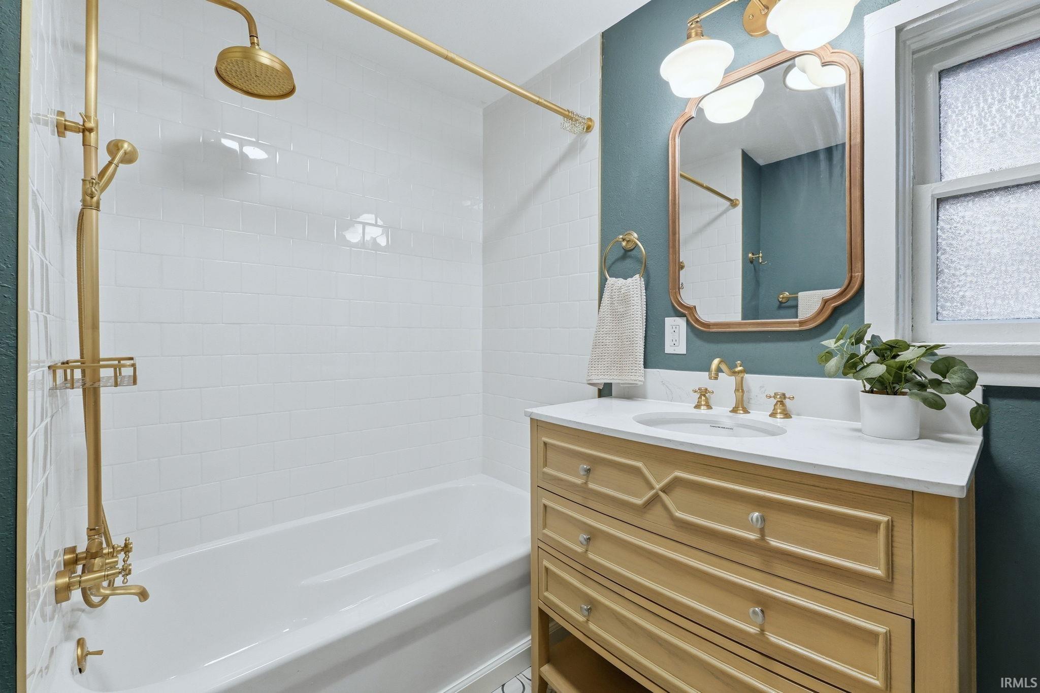 Bathroom featuring vanity and a combined bath / shower with rainfall shower