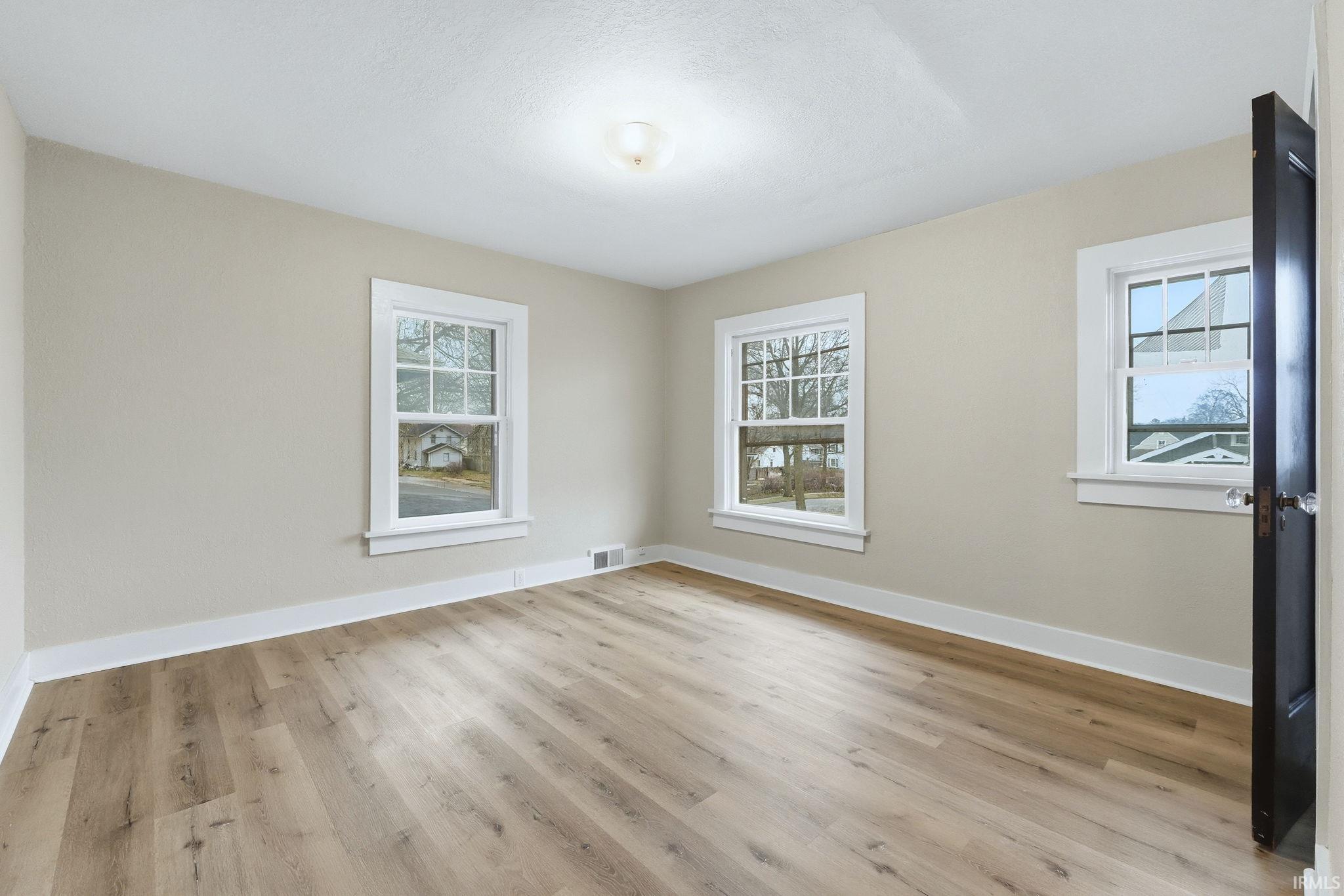 Empty room featuring baseboards and light wood finished floors