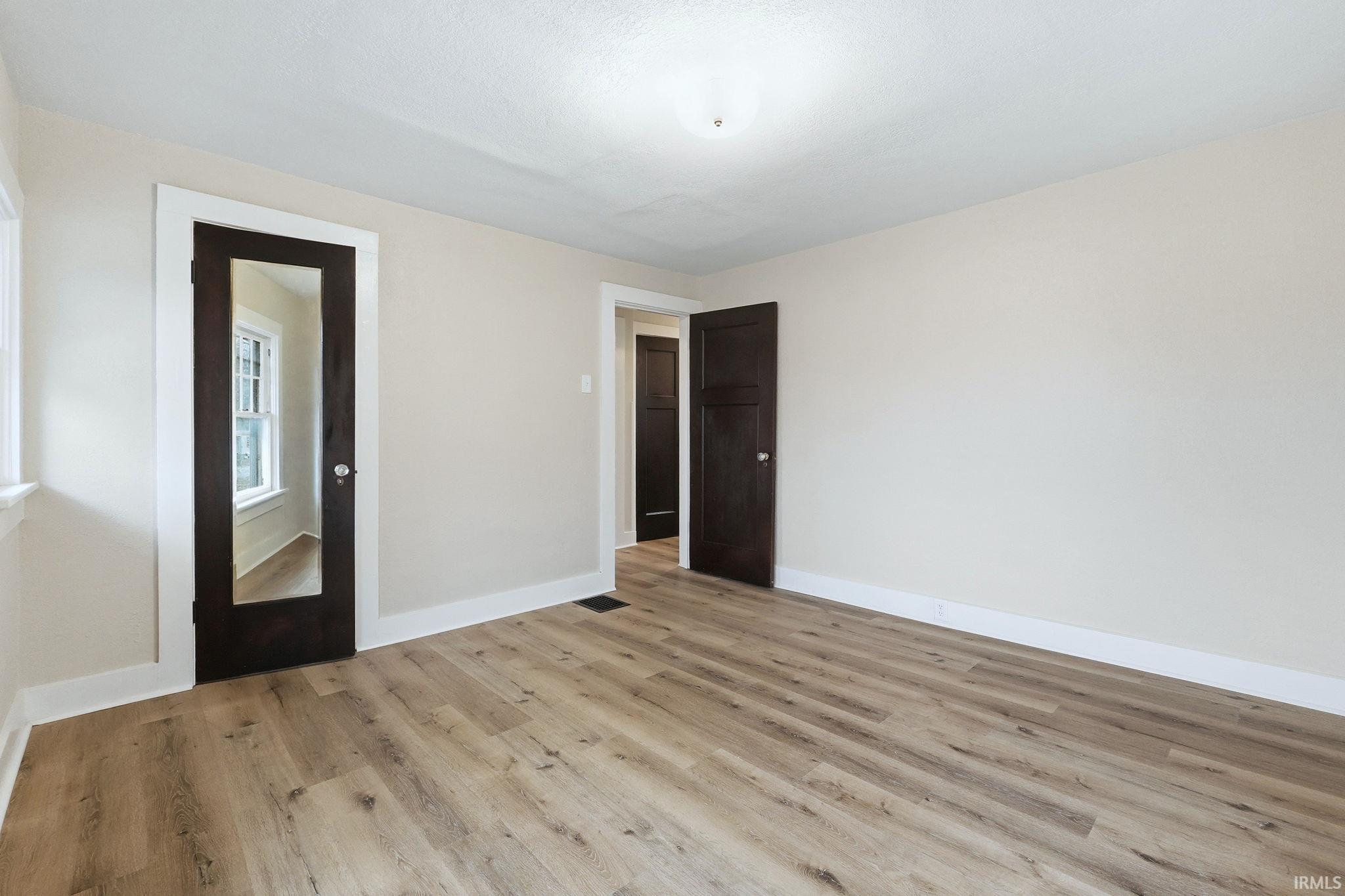 Empty room with baseboards and light wood-style floors