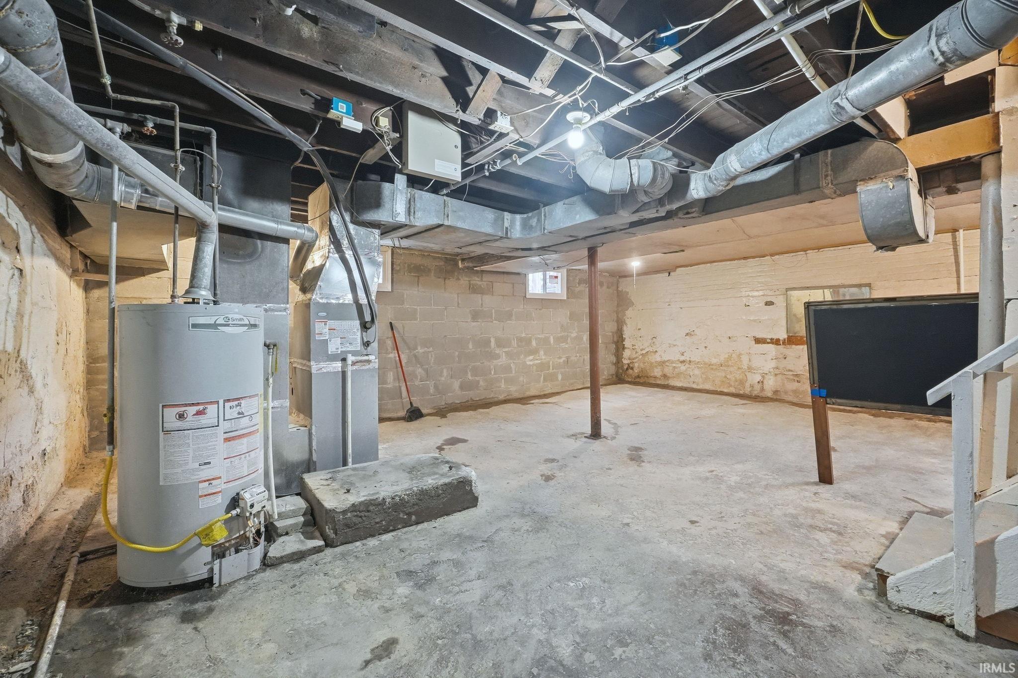 Unfinished below grade area featuring gas water heater