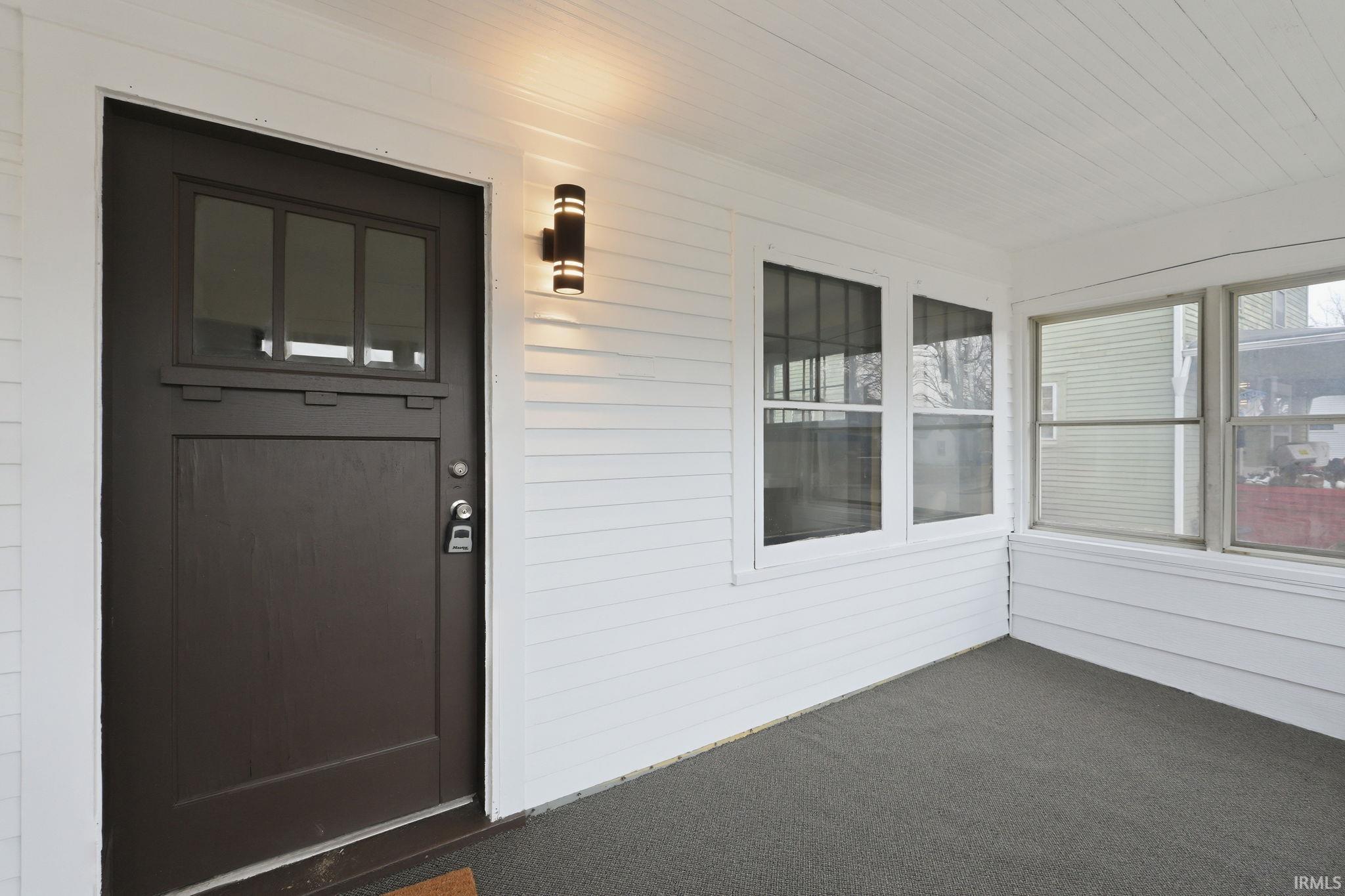 Entrance to property featuring a sunroom