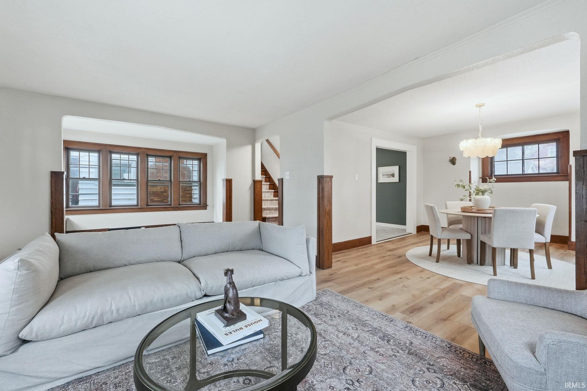 Living area featuring light wood-style floors, healthy amount of natural light, and suspended lighting