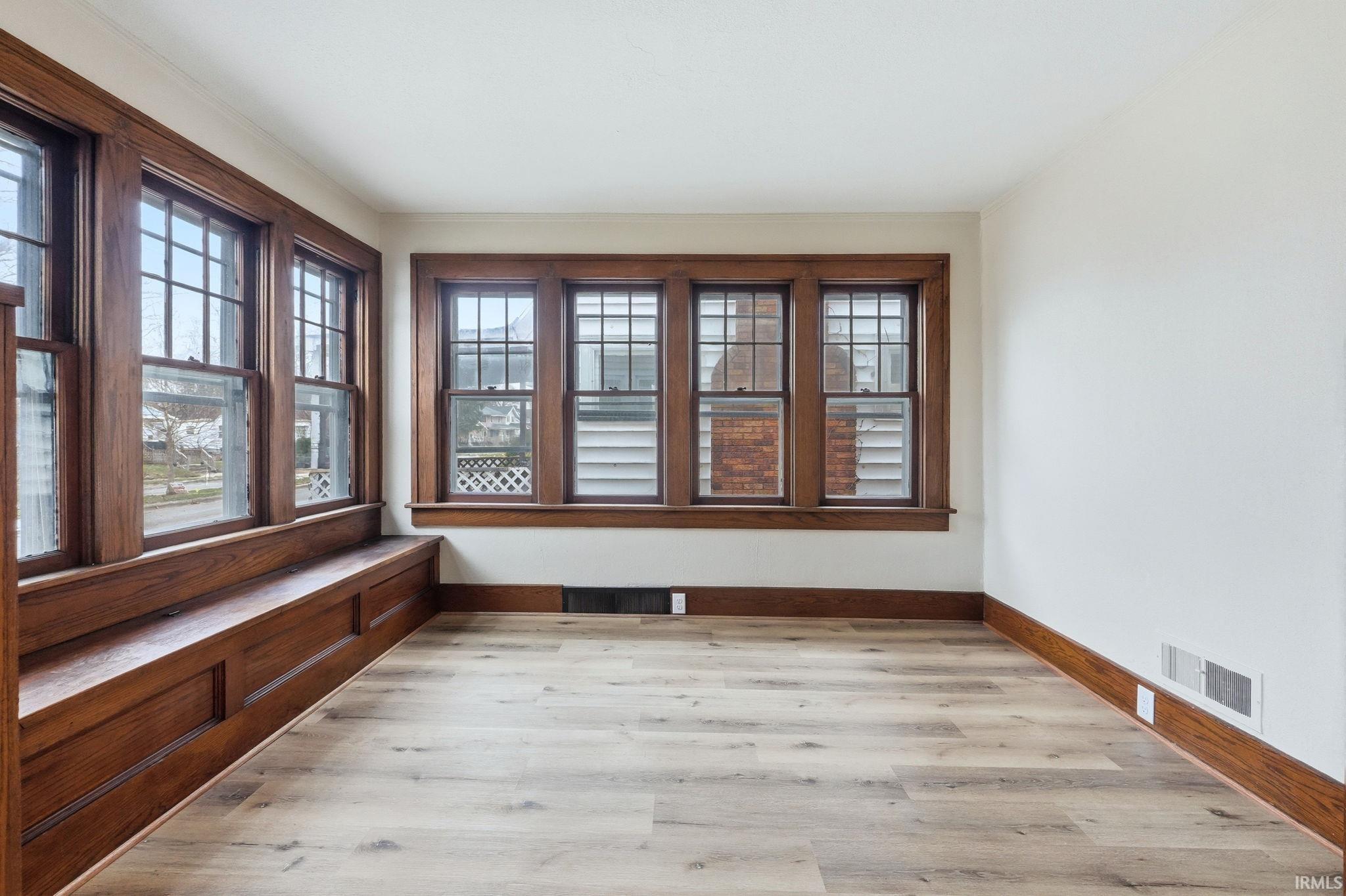 Unfurnished sunroom with baseboards and wood finished floors
