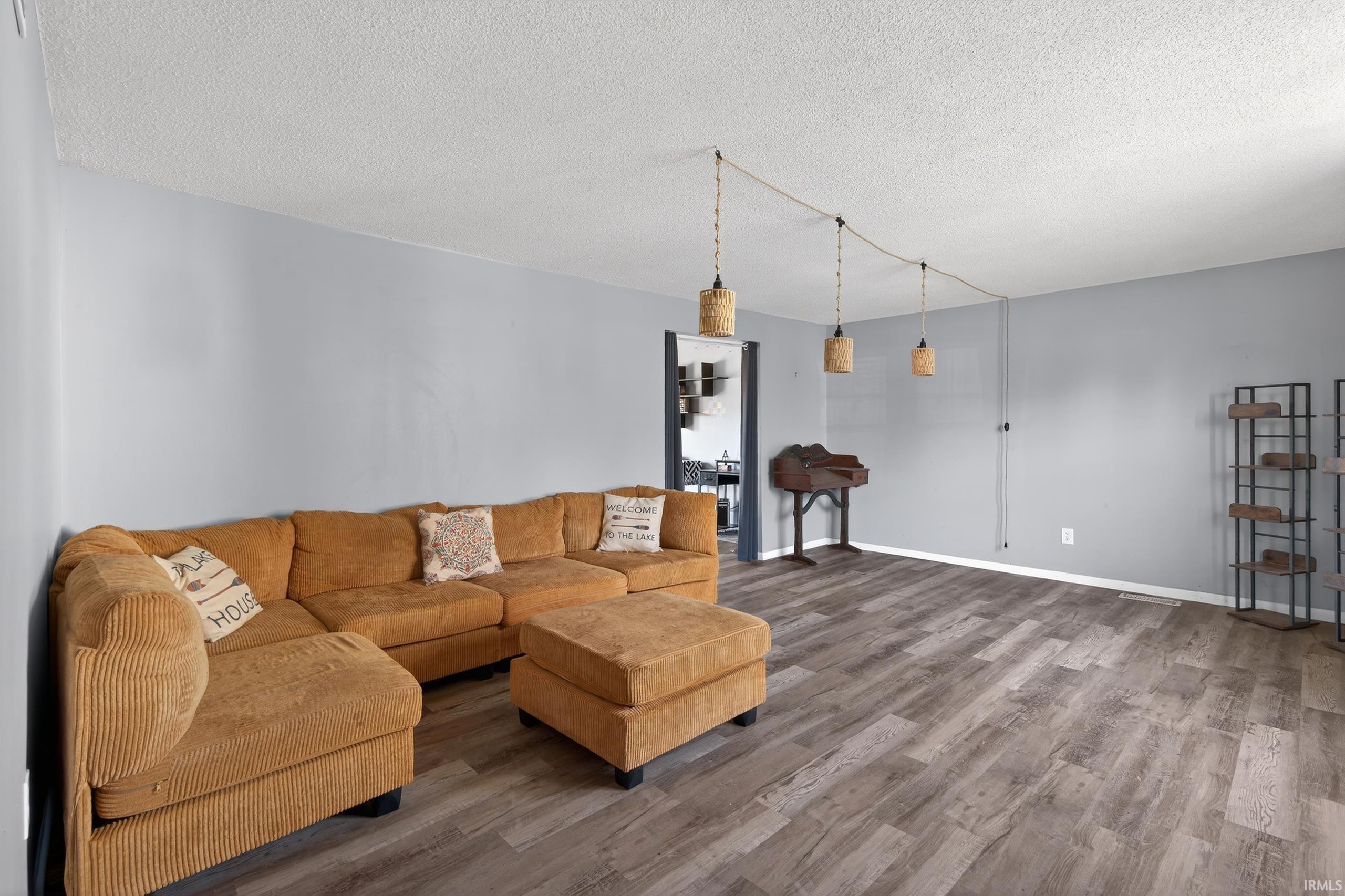 Living area featuring wood finished floors and a textured ceiling
