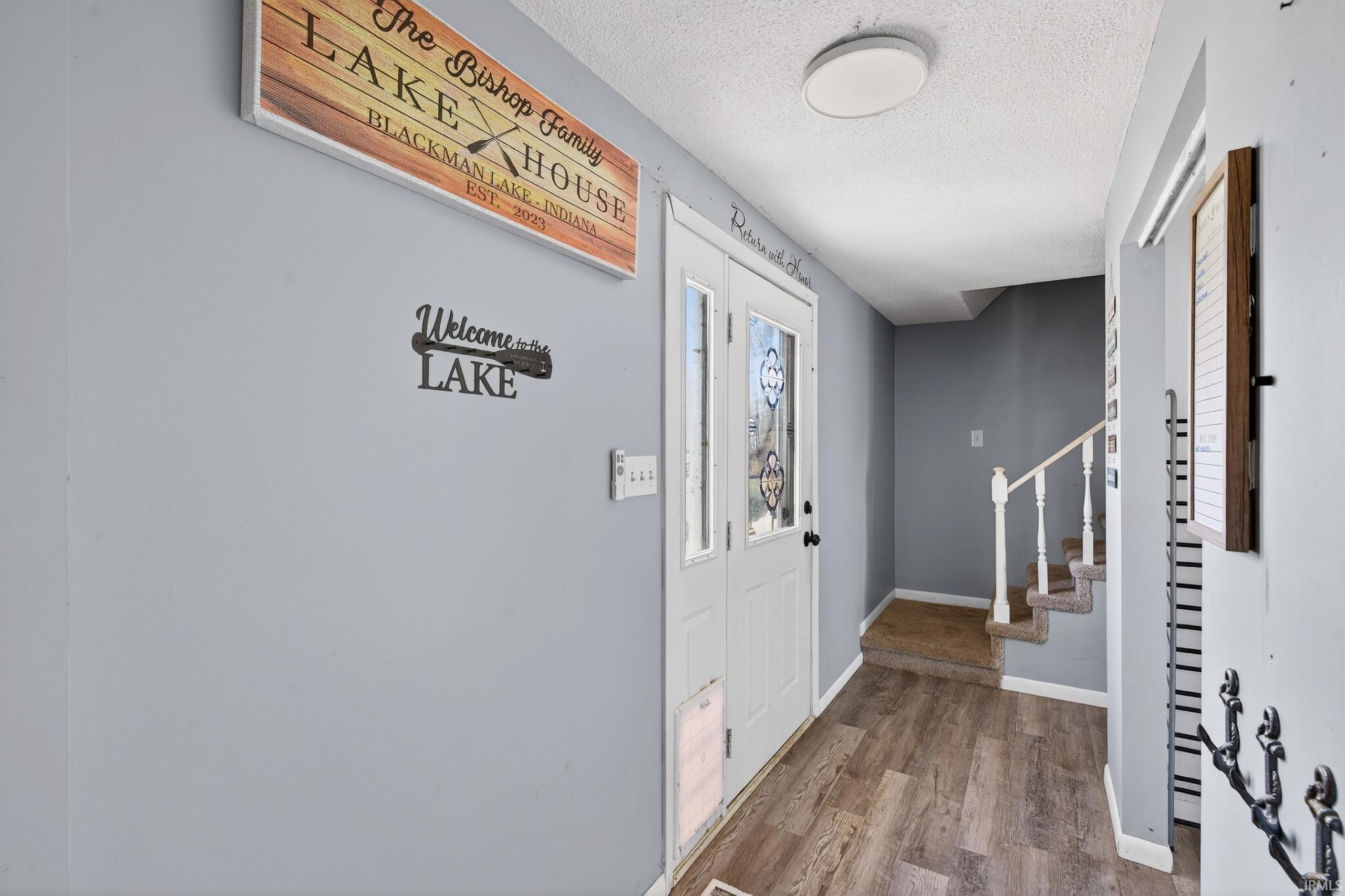 Entrance foyer featuring a textured ceiling and wood finished floors