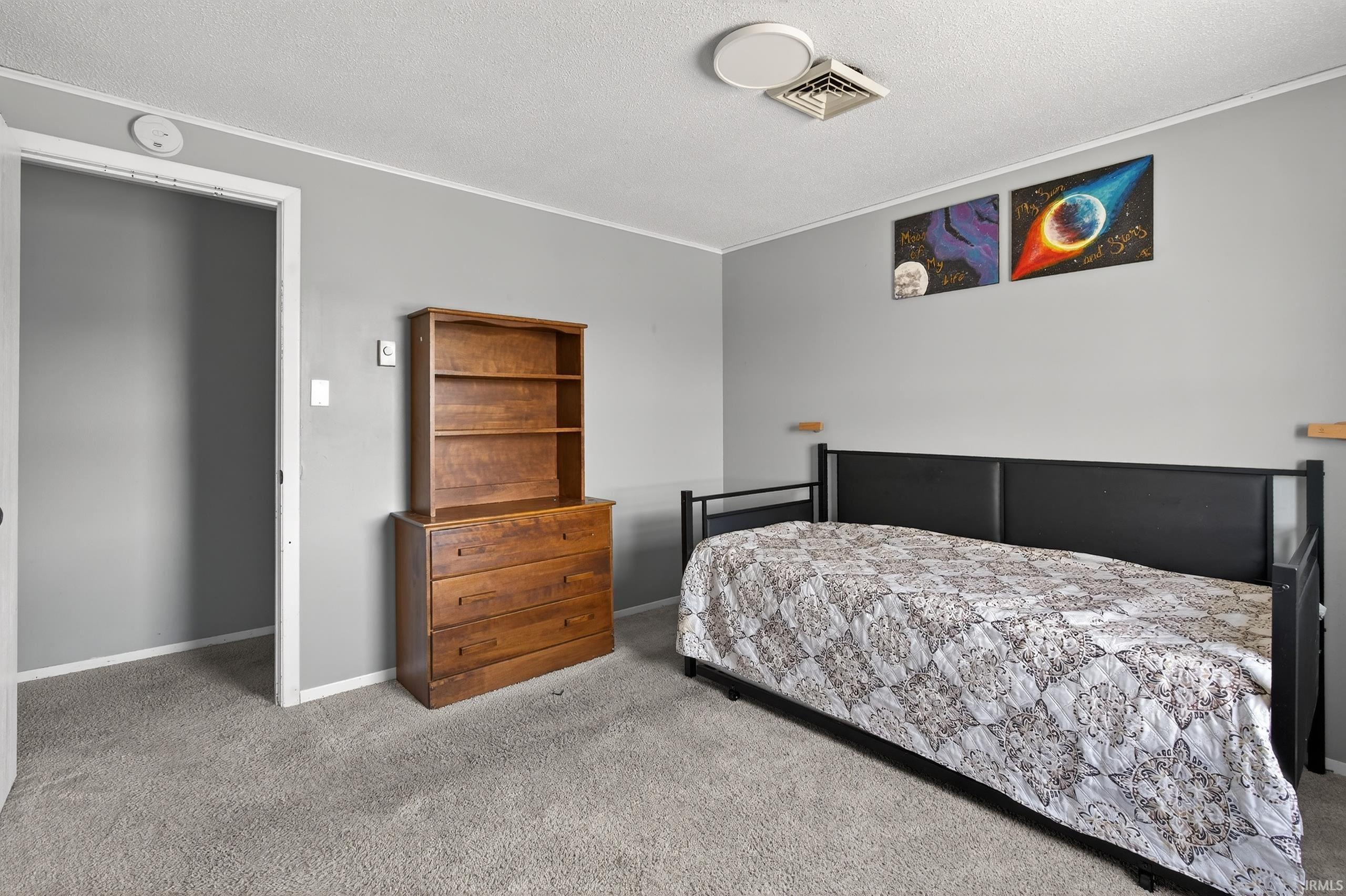 Bedroom featuring carpet flooring, a textured ceiling, and ornamental molding
