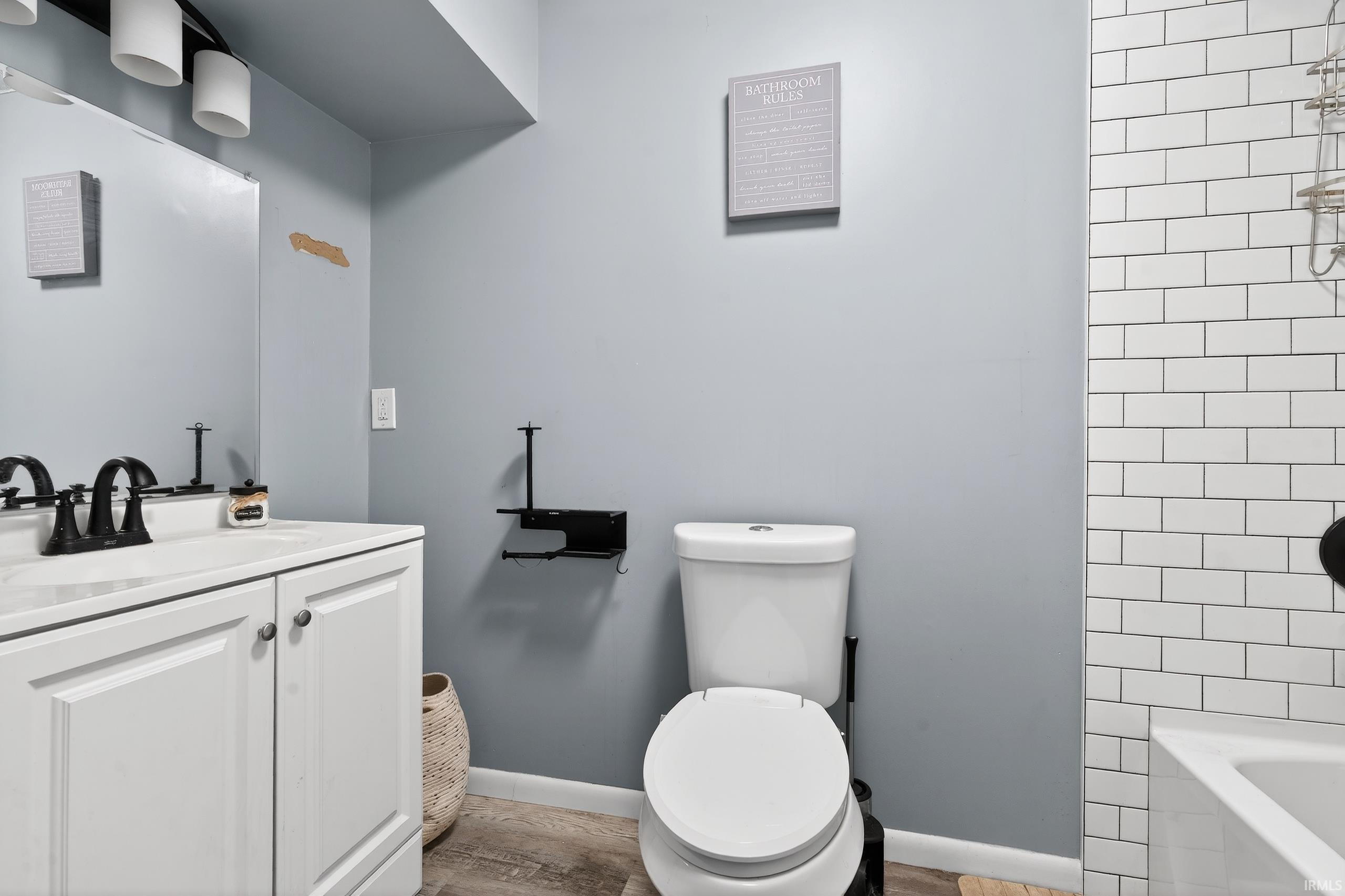 Full bath featuring vanity, light wood-style floors, and tub / shower combination