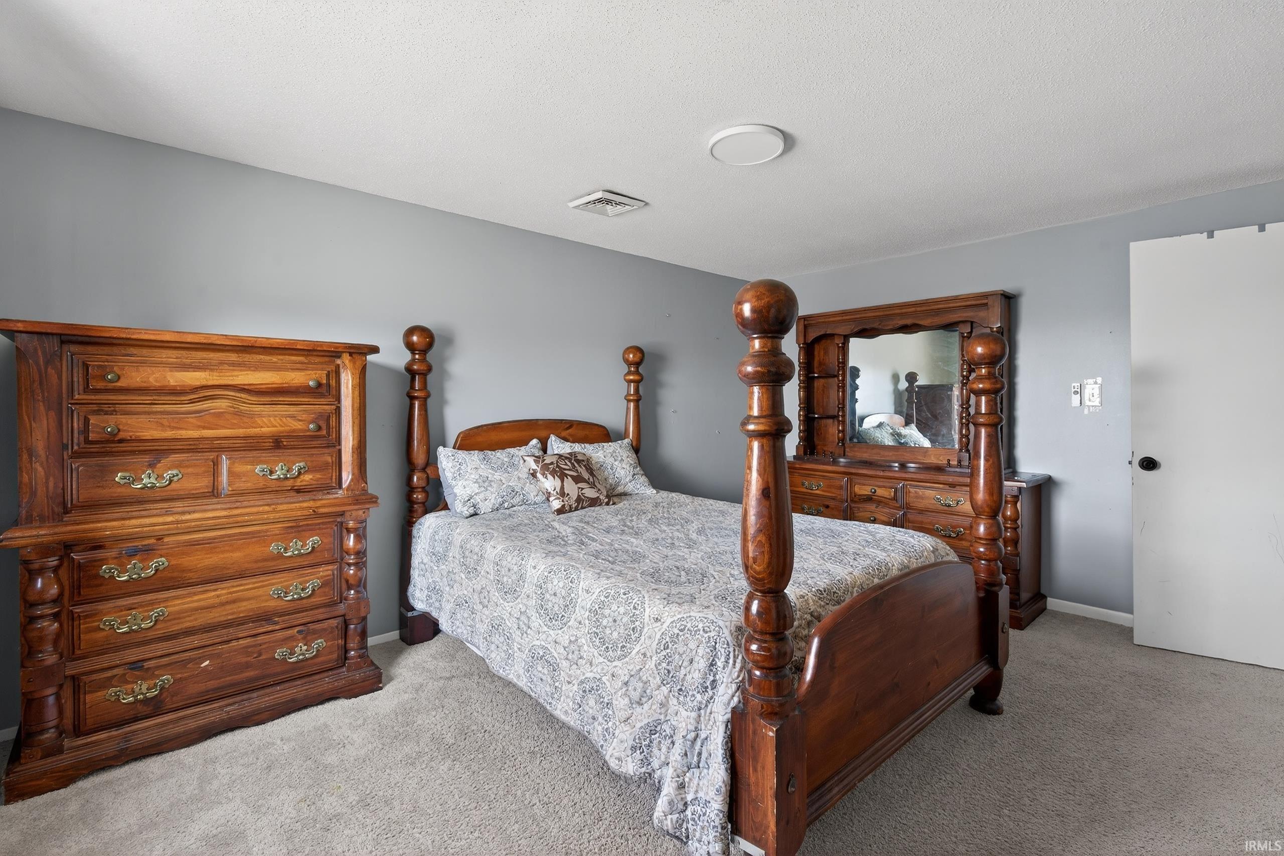 Bedroom featuring light carpet and baseboards