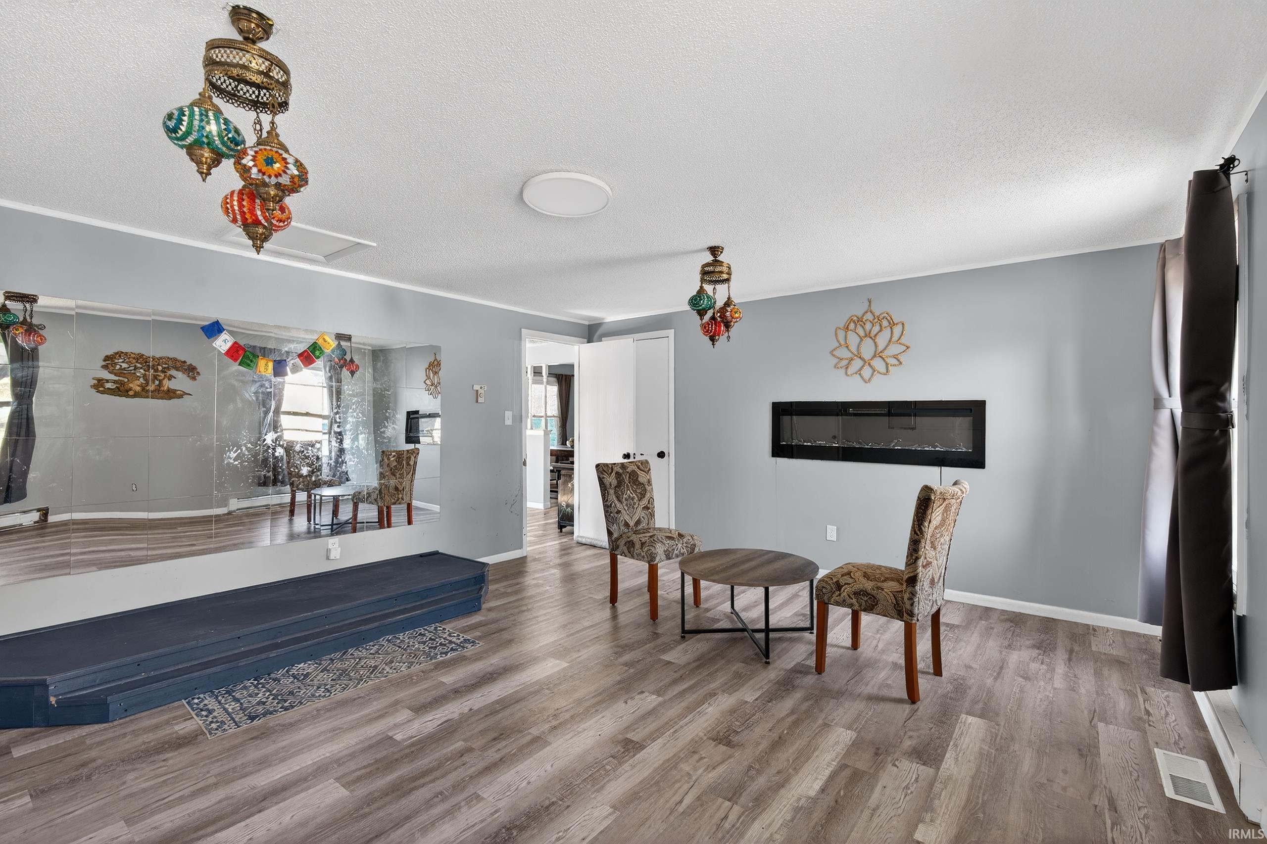Sitting room featuring light wood-type flooring and a textured ceiling