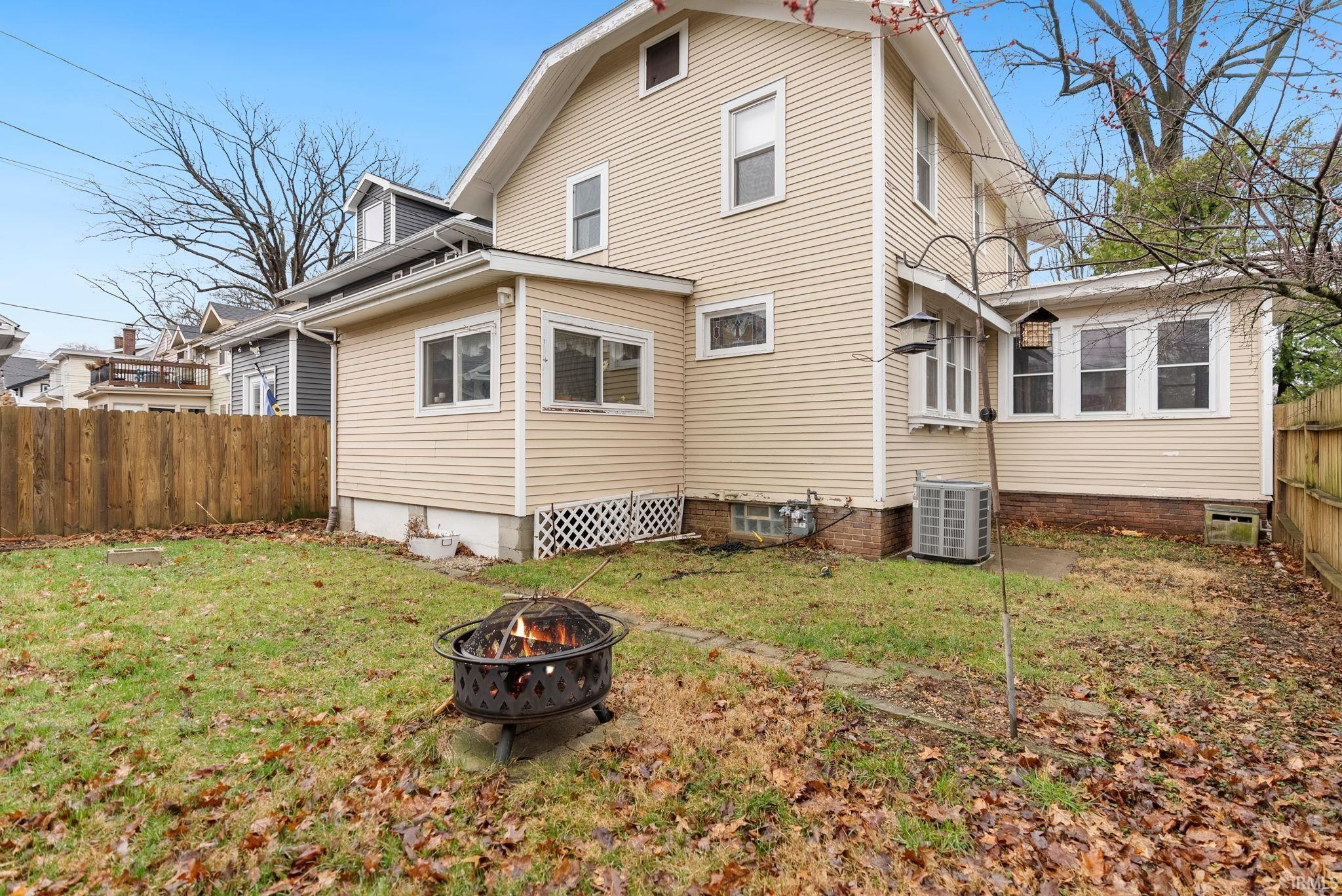 Back of property featuring an outdoor fire pit