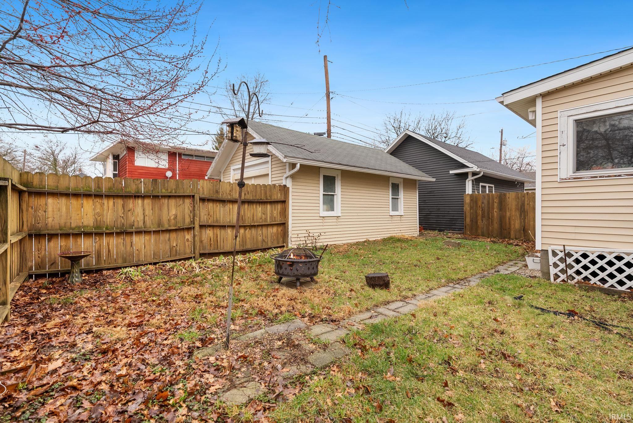 Fenced backyard with a fire pit