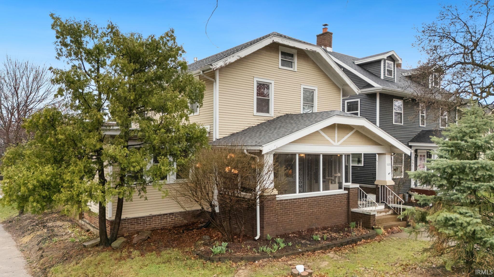 Traditional style home featuring a sunroom, a chimney, and roof with shingles