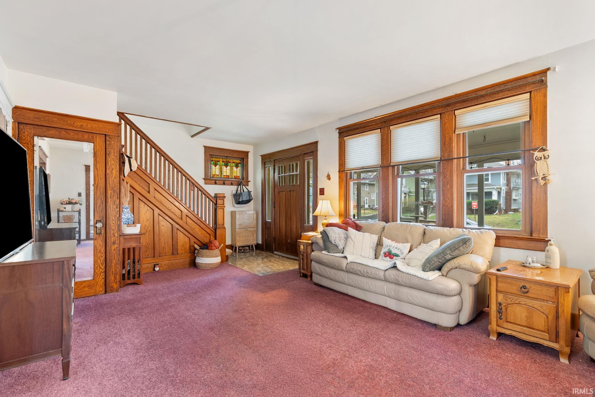 Living room with carpet flooring and stairs