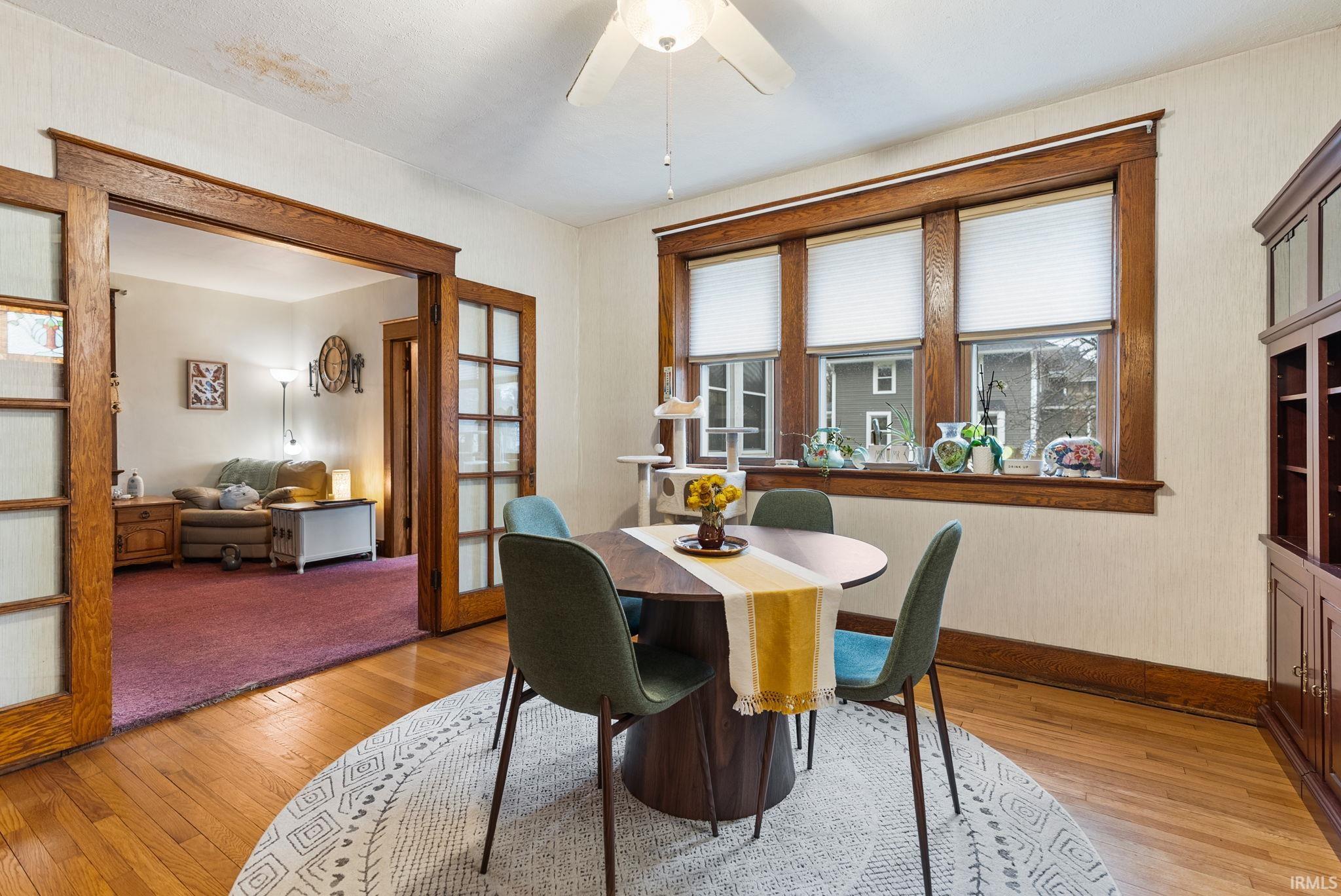 Dining space featuring light wood finished floors, a ceiling fan, and french doors