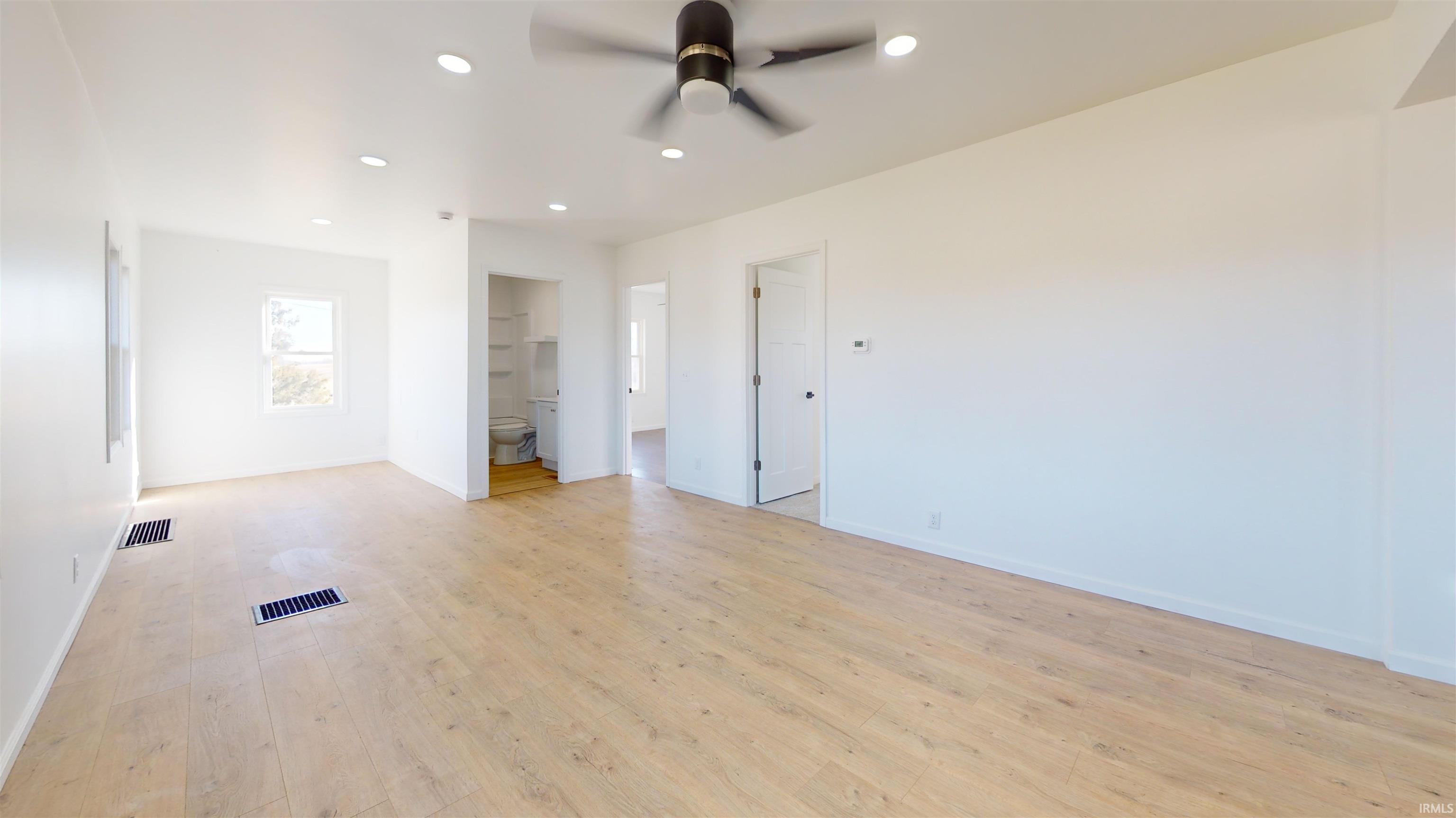 Unfurnished bedroom with recessed lighting, ensuite bath, light wood-style flooring, and ceiling fan