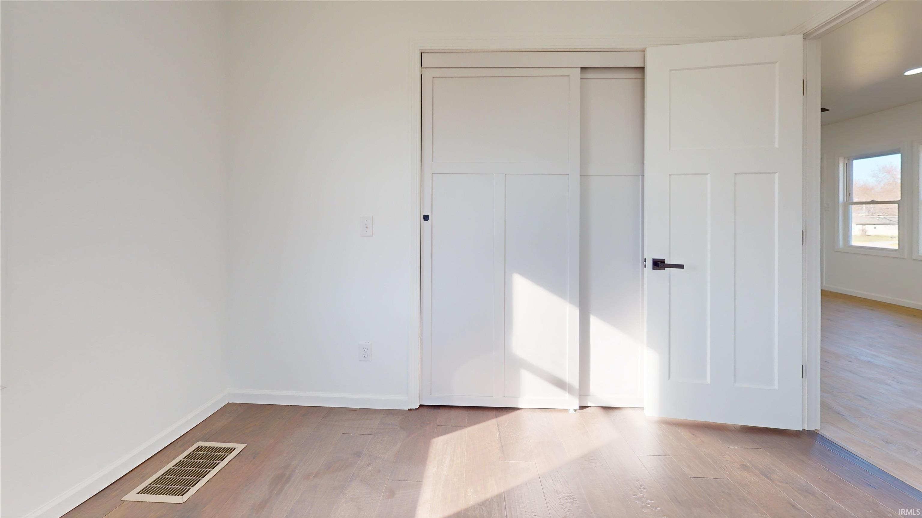 Unfurnished bedroom with a closet and light wood-type flooring