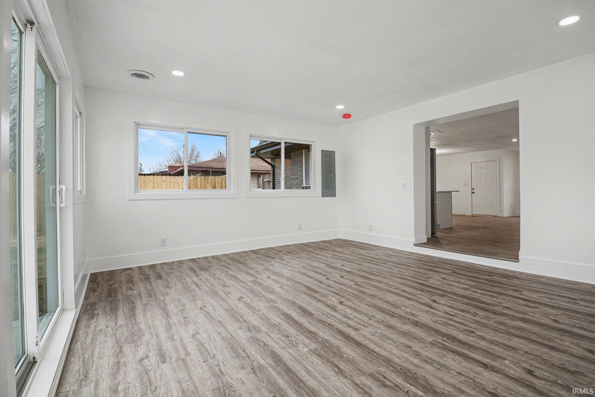 light wood-type flooring, recessed lighting, and electric panel