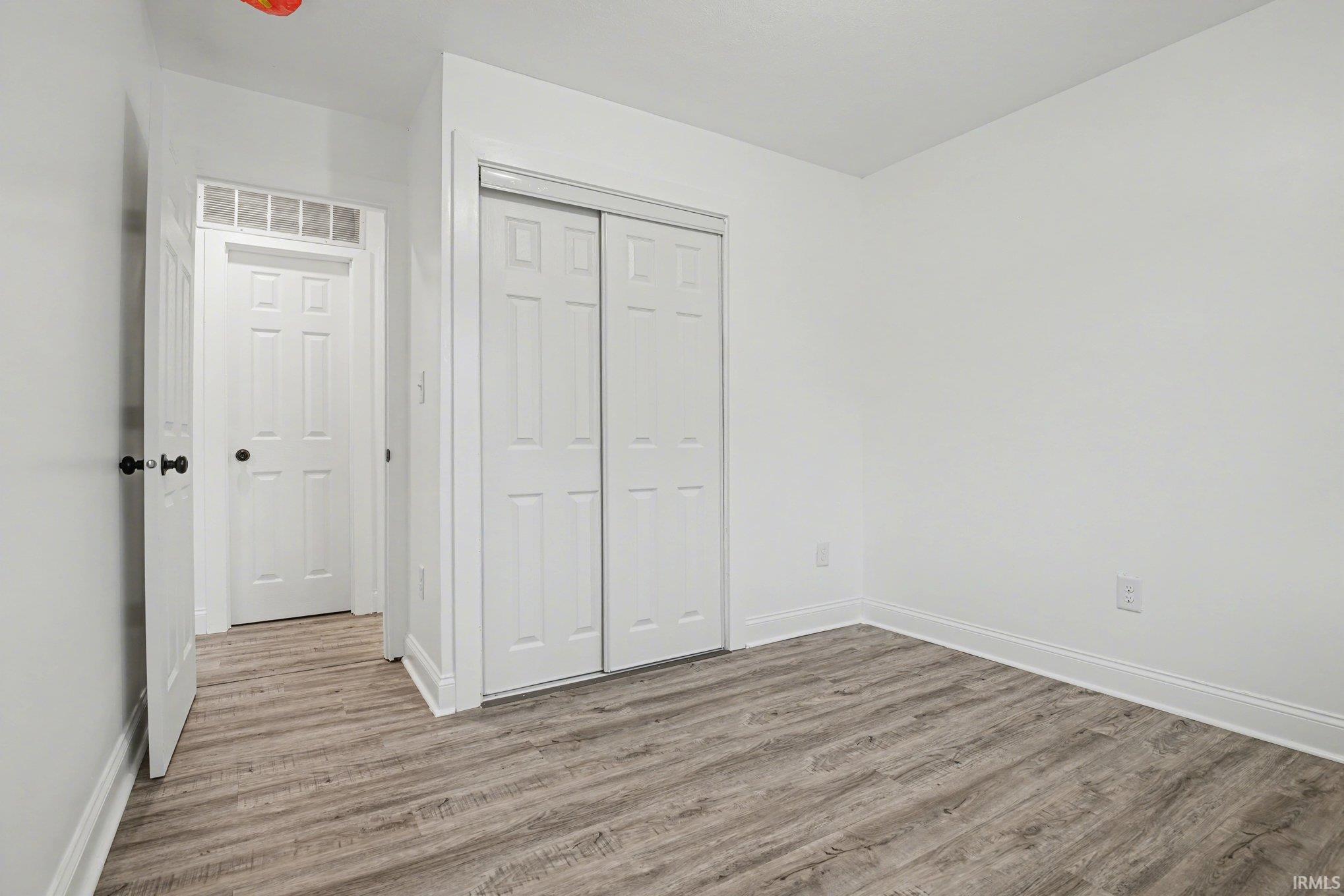 Unfurnished bedroom featuring a closet and light wood-type flooring