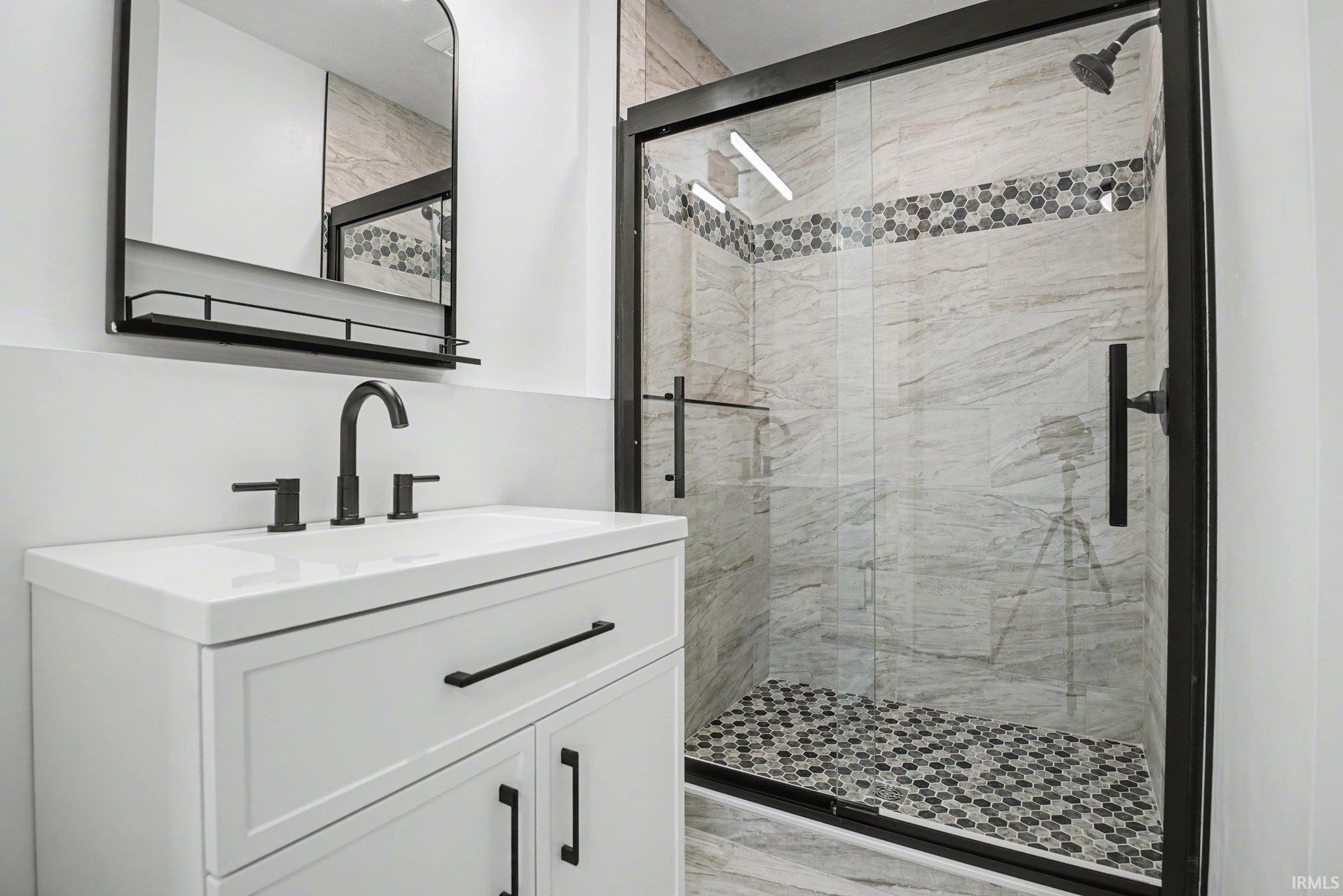 Primary Bathroom featuring vanity and tile finished shower