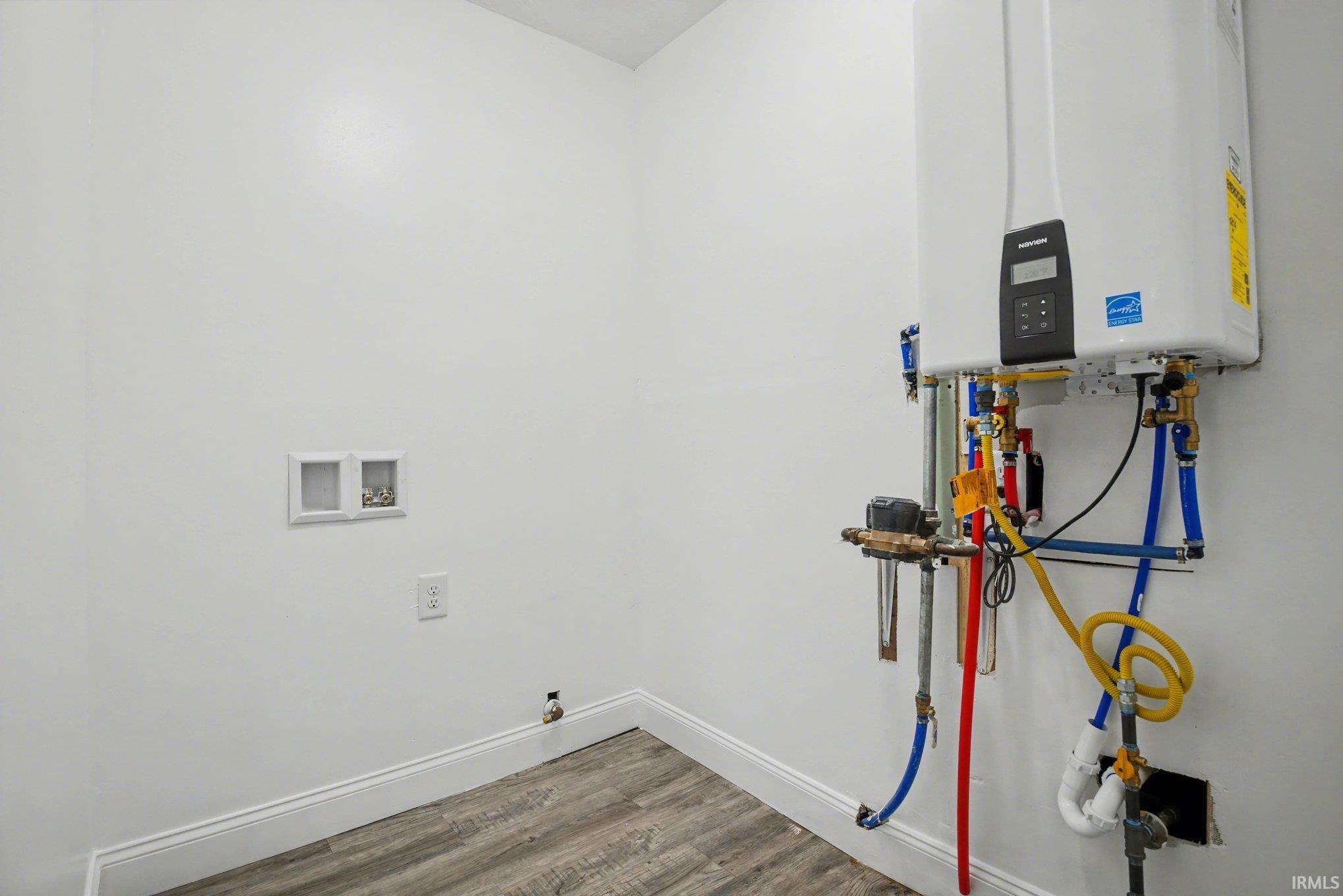 Laundry area with hookup for a washing machine, wood finished floors, water heater, and hookup for a gas dryer