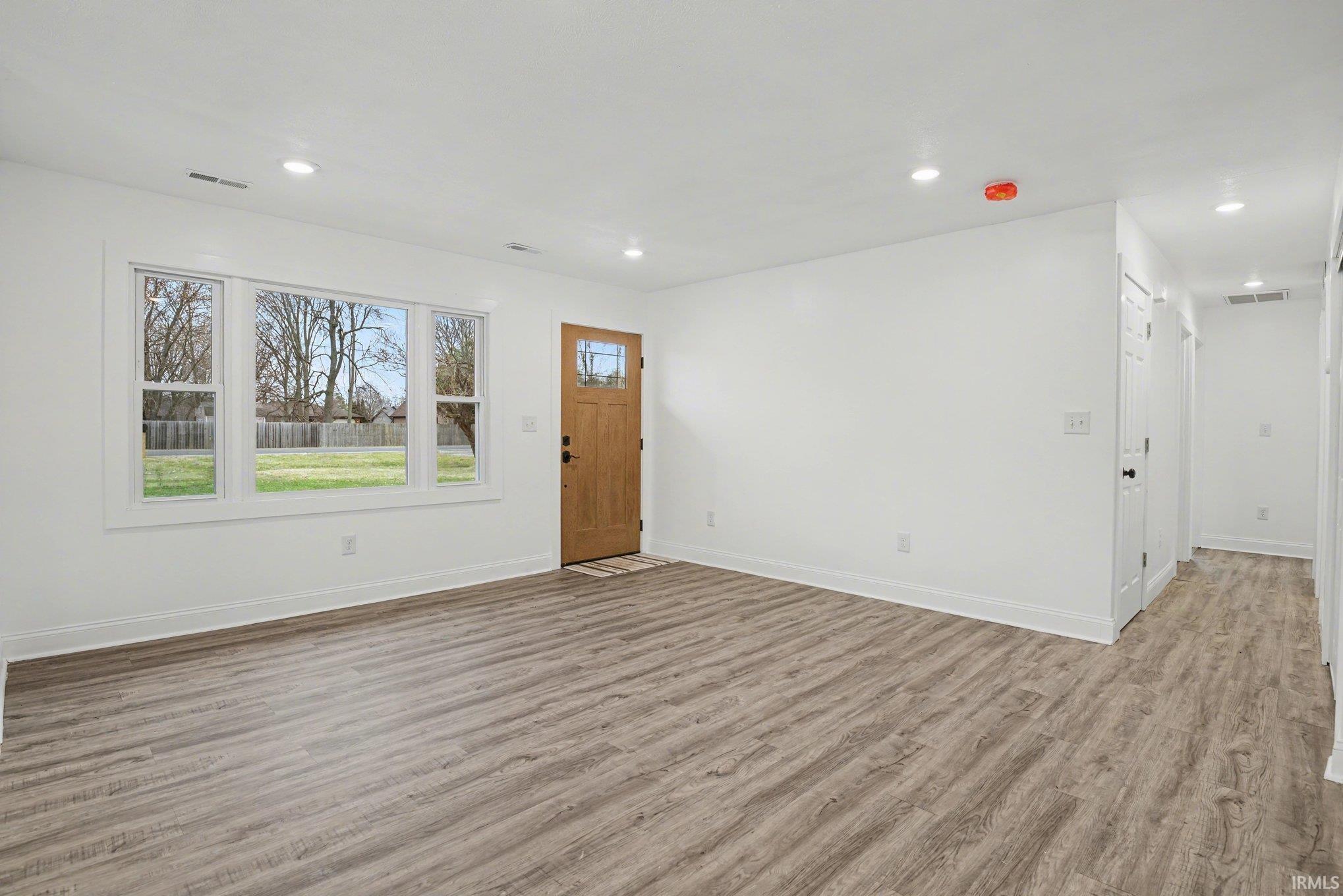 Foyer entrance with light wood-type flooring and recessed lighting