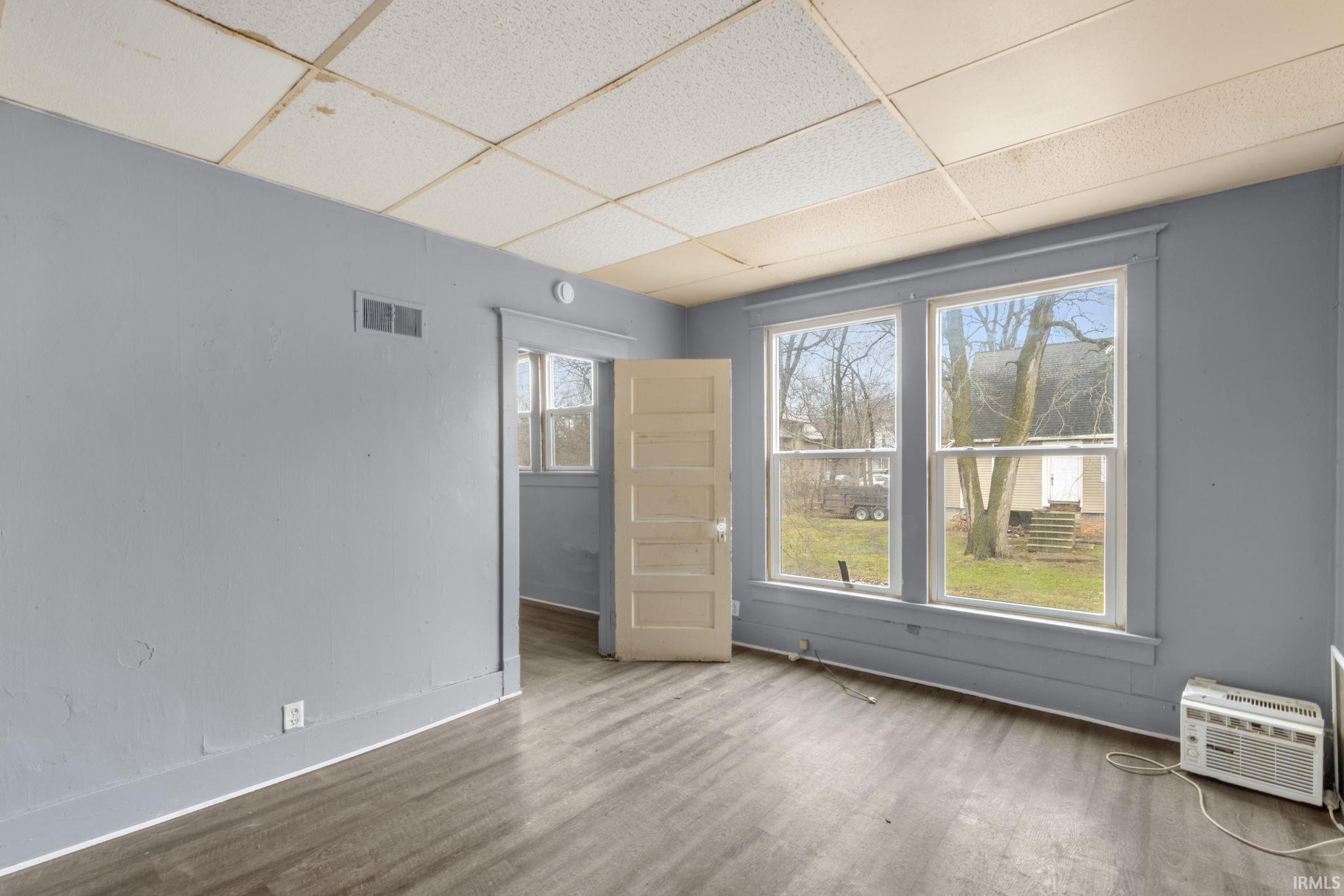 Spare room featuring a drop ceiling and wood finished floors