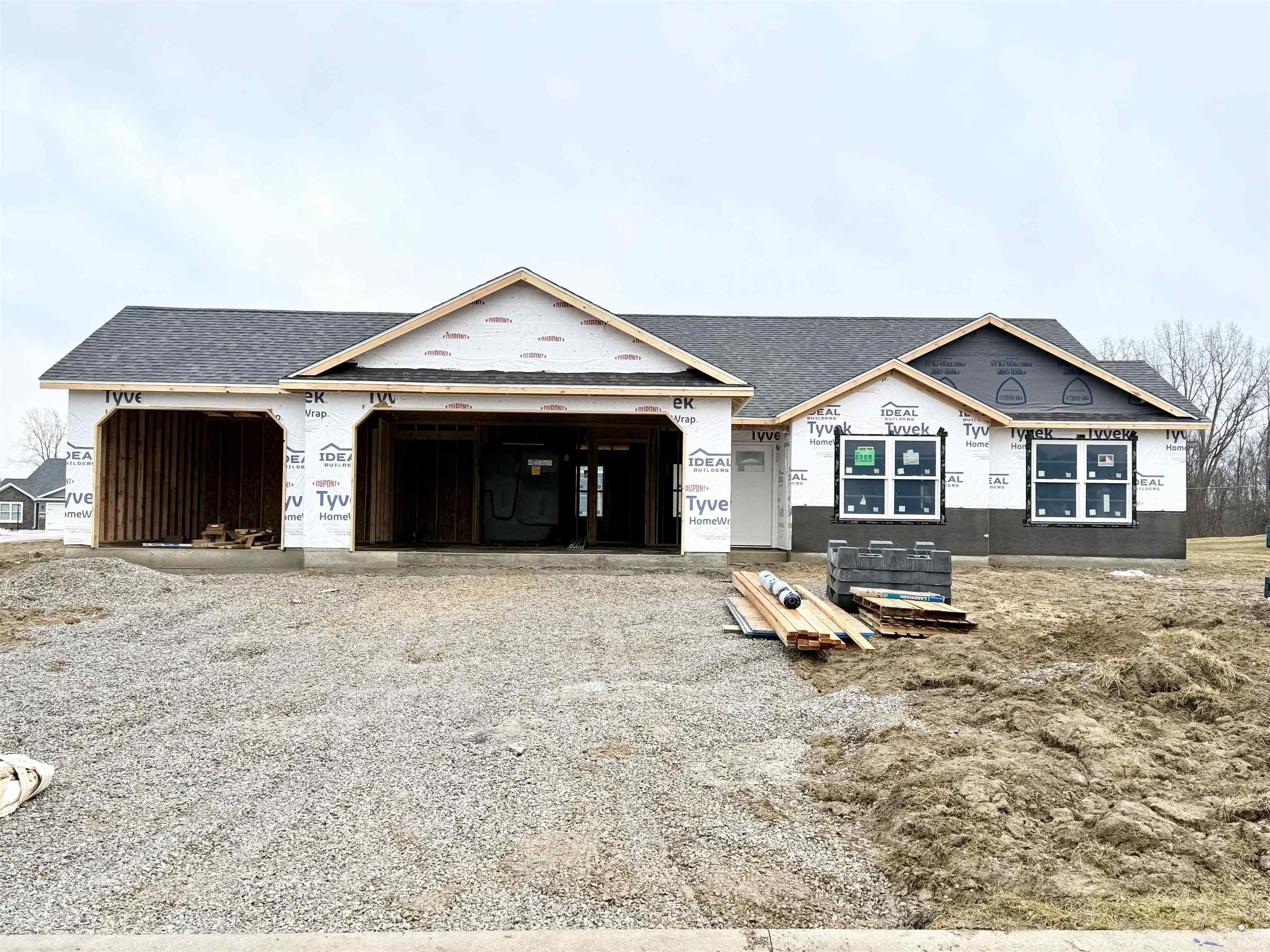 Property under construction featuring driveway, a garage, and a shingled roof