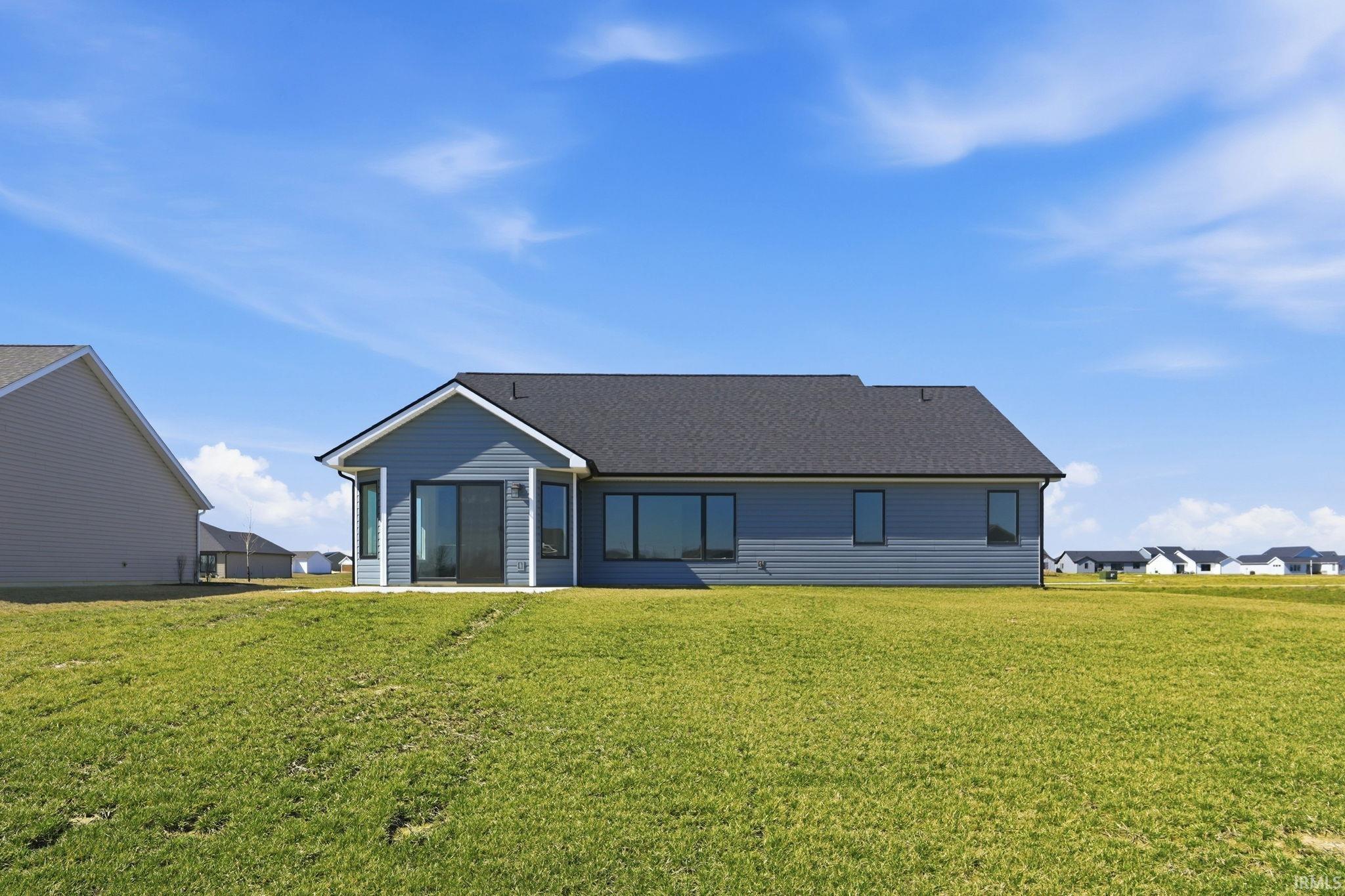 Rear view of property featuring a yard and a shingled roof