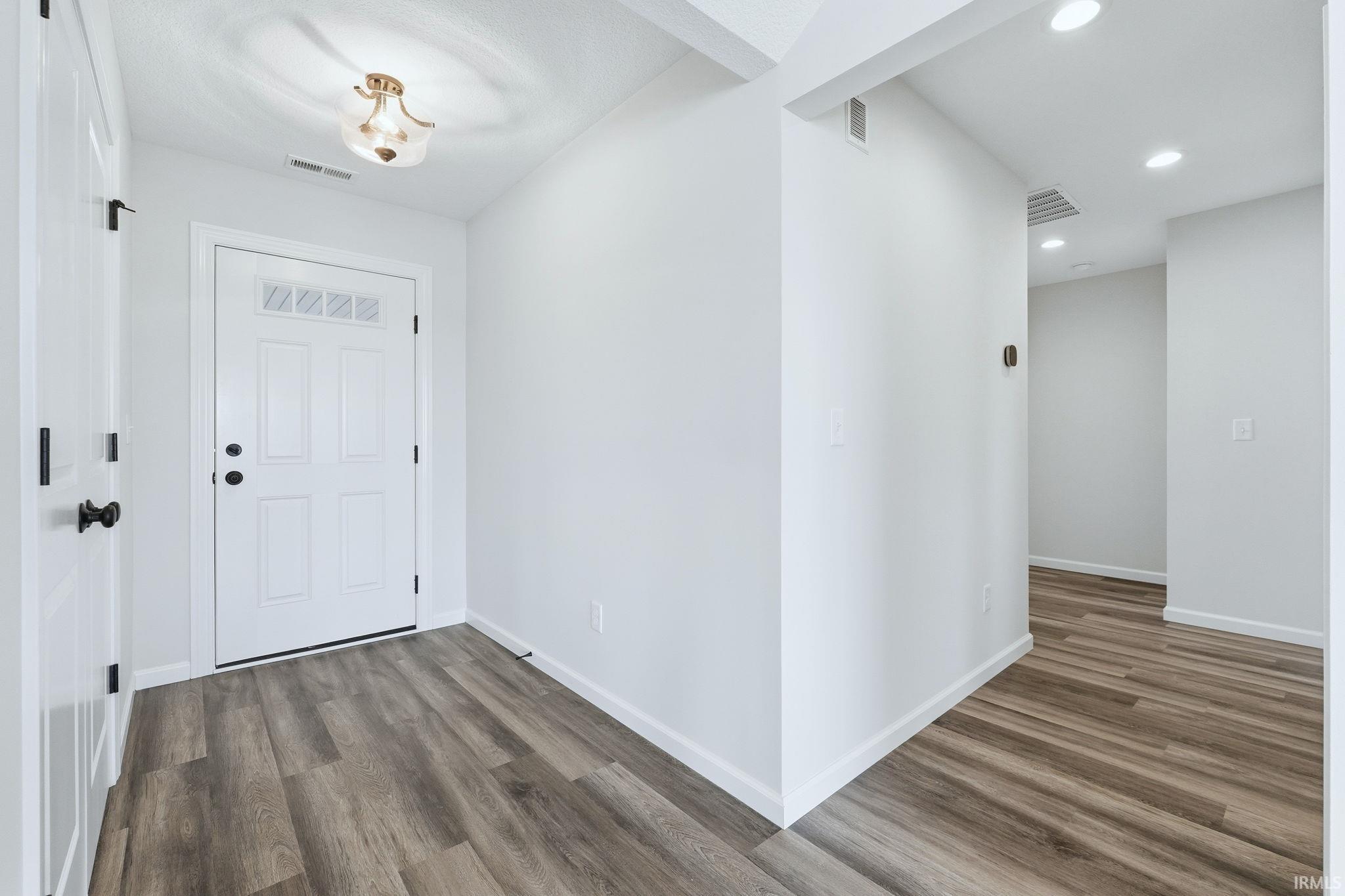 Entryway featuring dark wood finished floors and recessed lighting