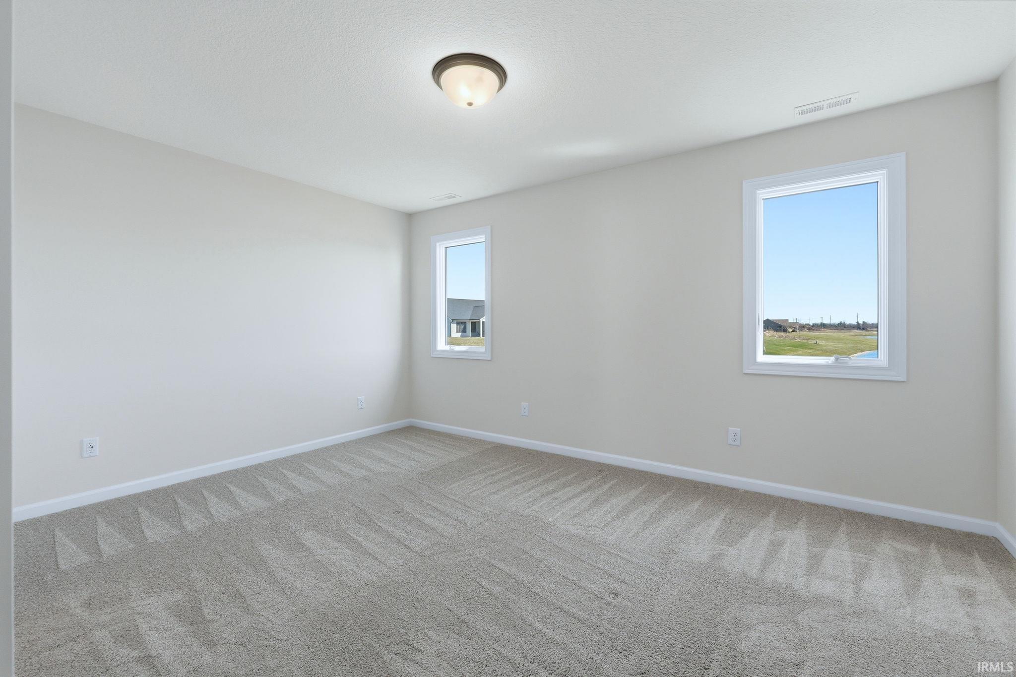 Spare room with light colored carpet and baseboards