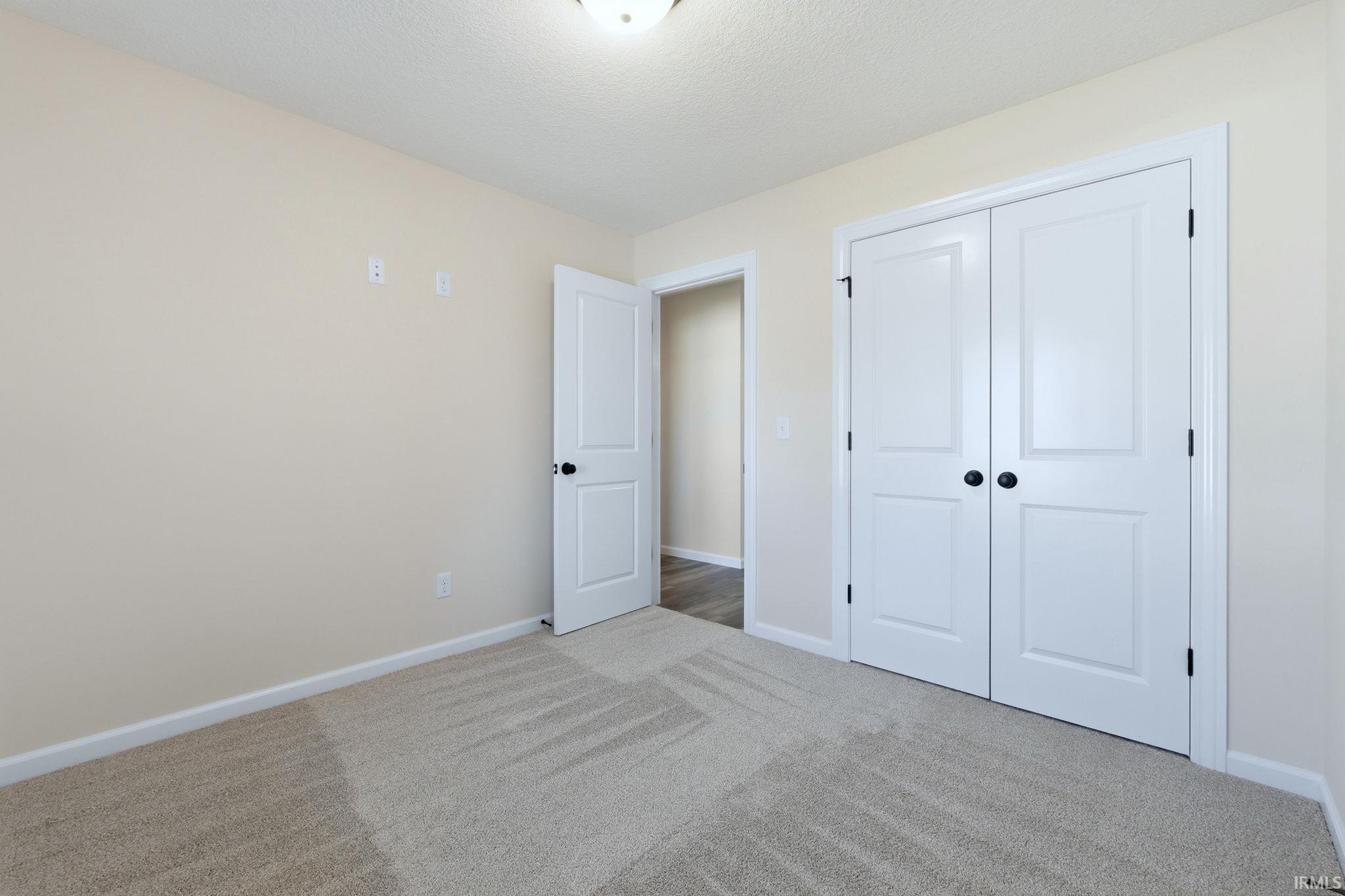 Unfurnished bedroom featuring carpet, a closet, and a textured ceiling