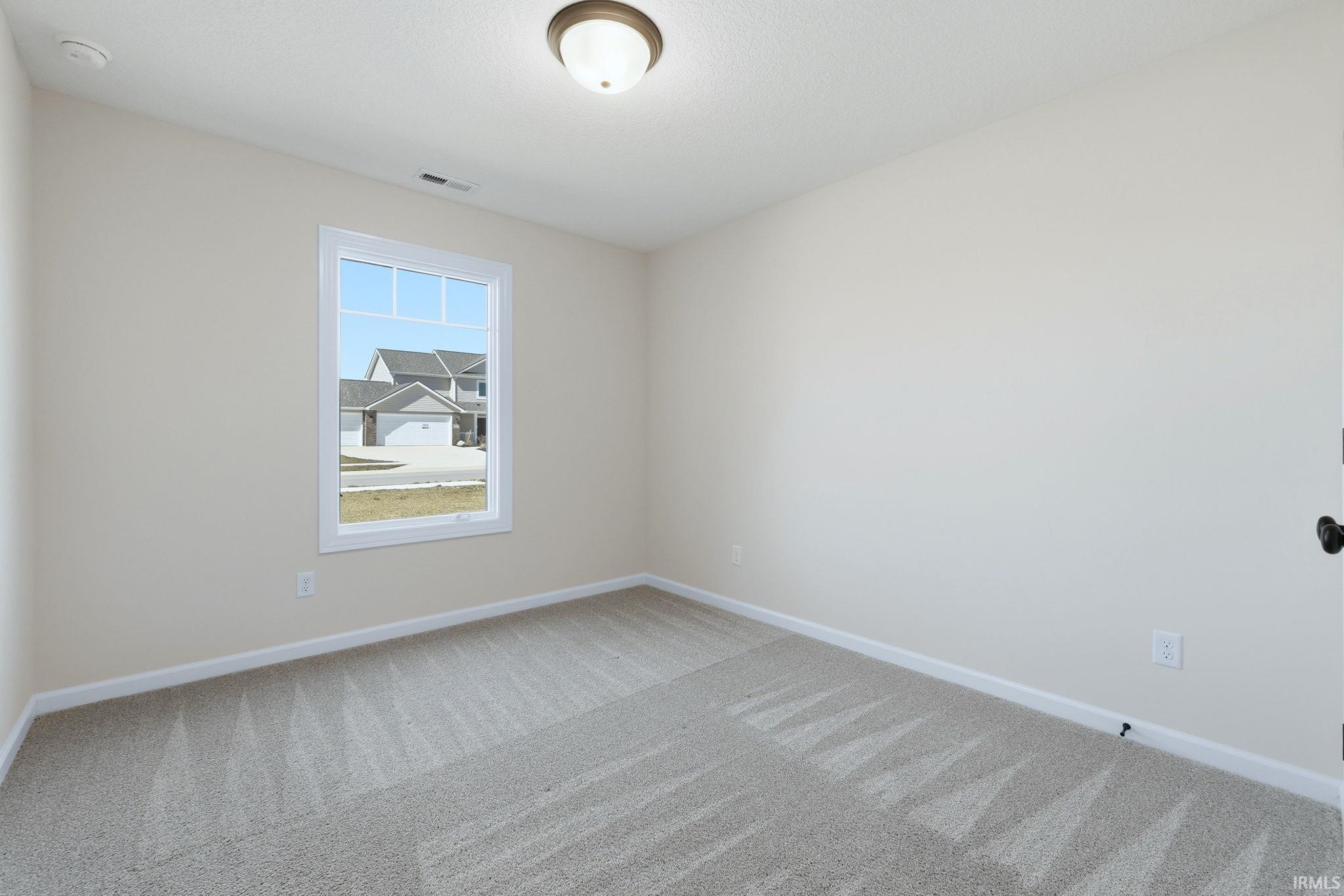 Spare room featuring baseboards and light carpet